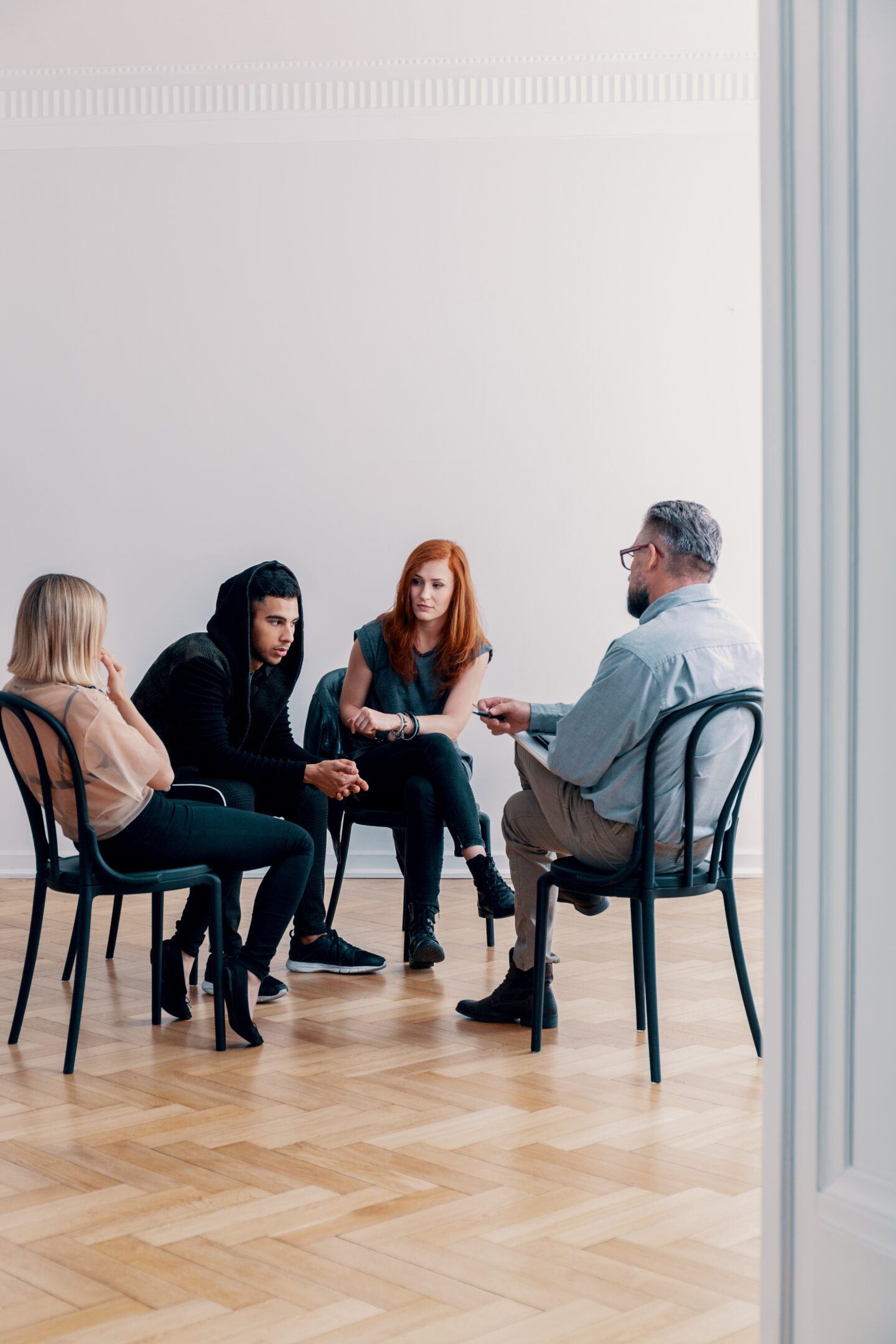 Group of three people talking to a psychologist in a rehab facility