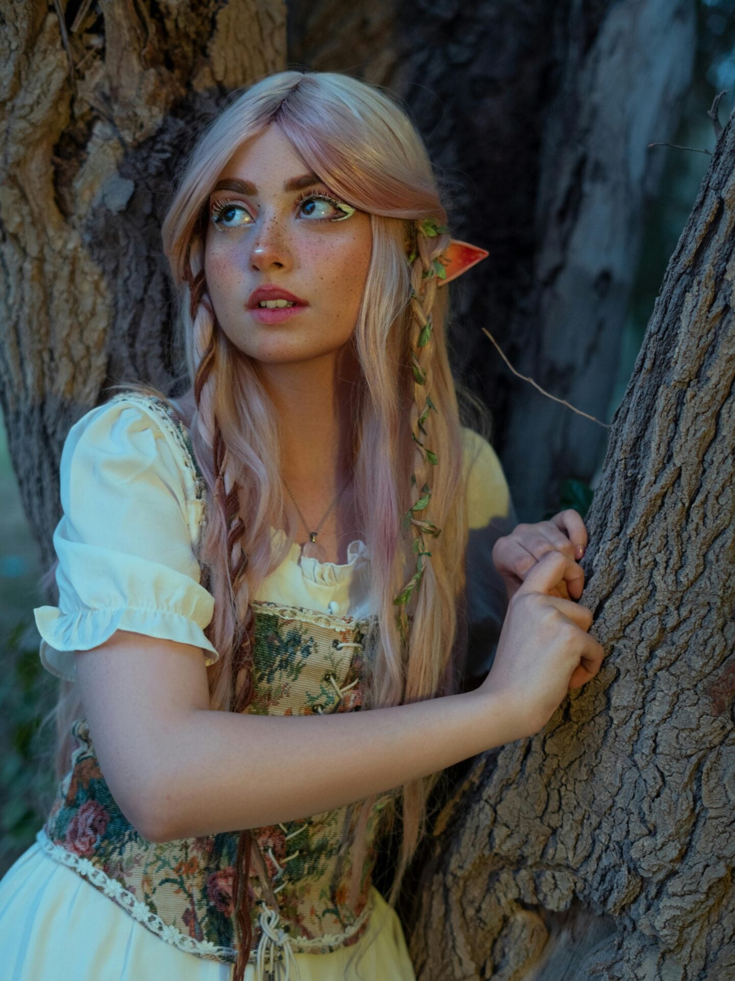 Fantasy elf cosplay with long pink hair and pointed ears at Renaissance fair