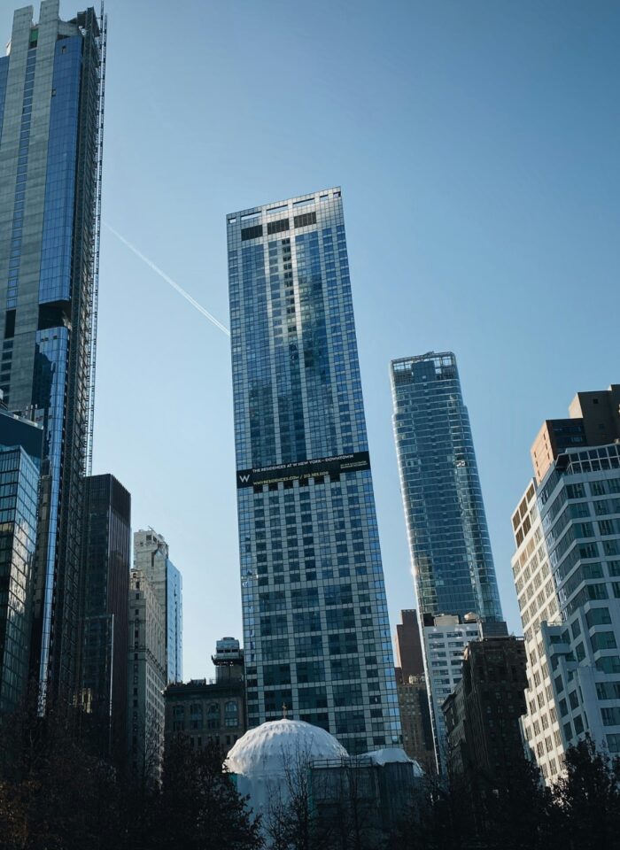 Modern city skyline with high-rise office buildings in downtown Manhattan, New York City, under clear blue sky.