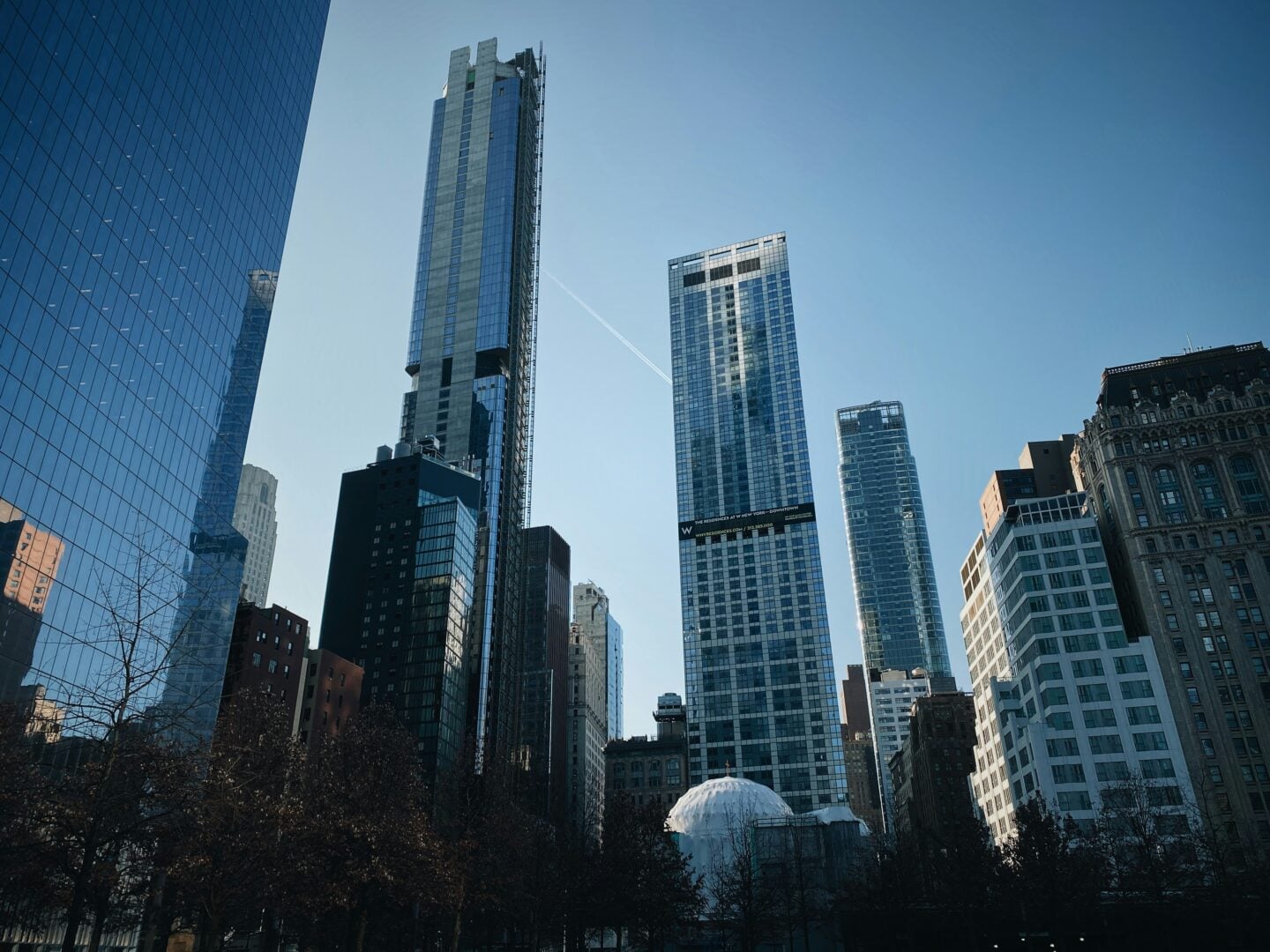 Modern city skyline with high-rise office buildings in downtown Manhattan, New York City, under clear blue sky.
