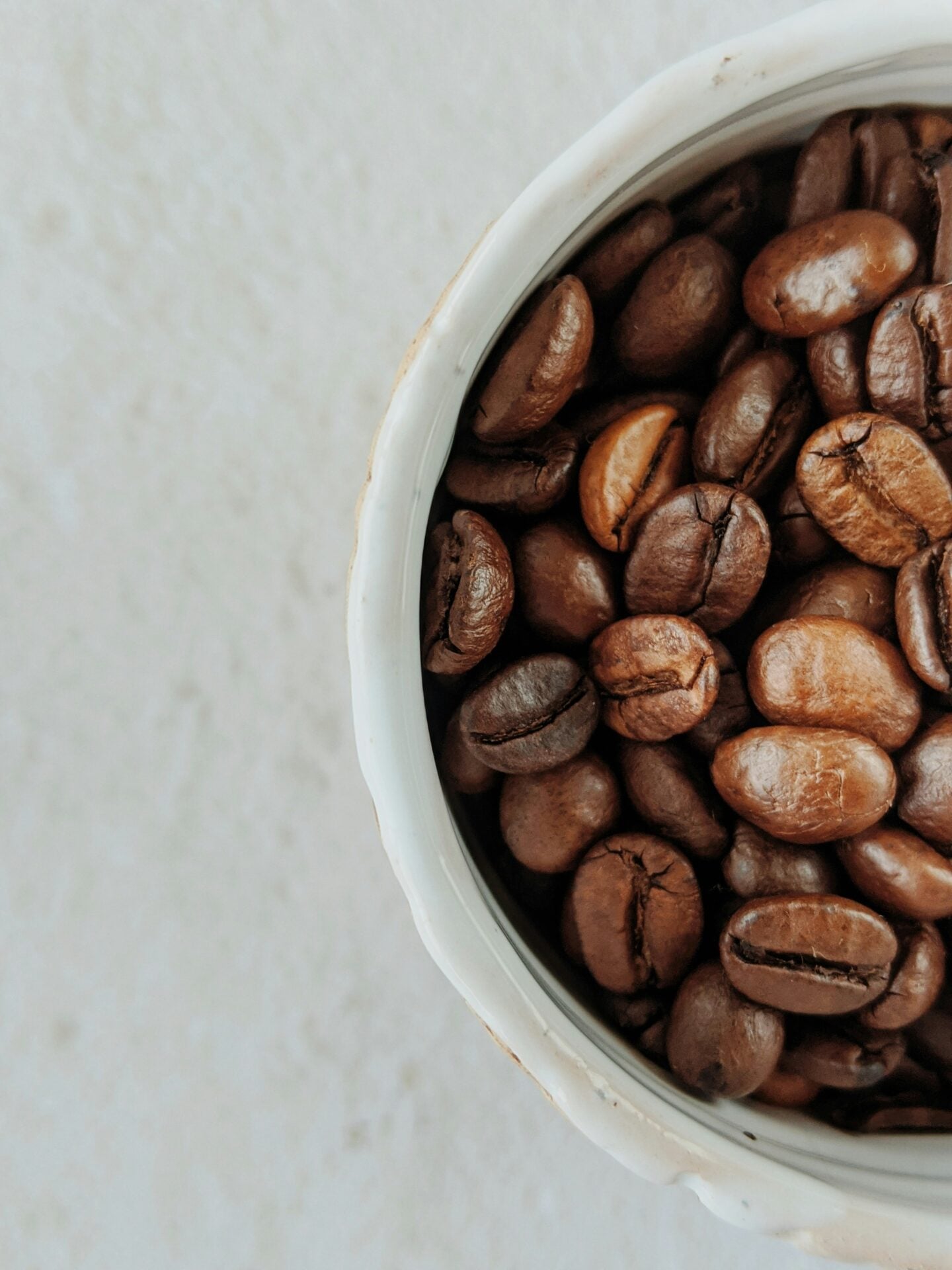Close-up of roasted coffee beans in a ceramic cup