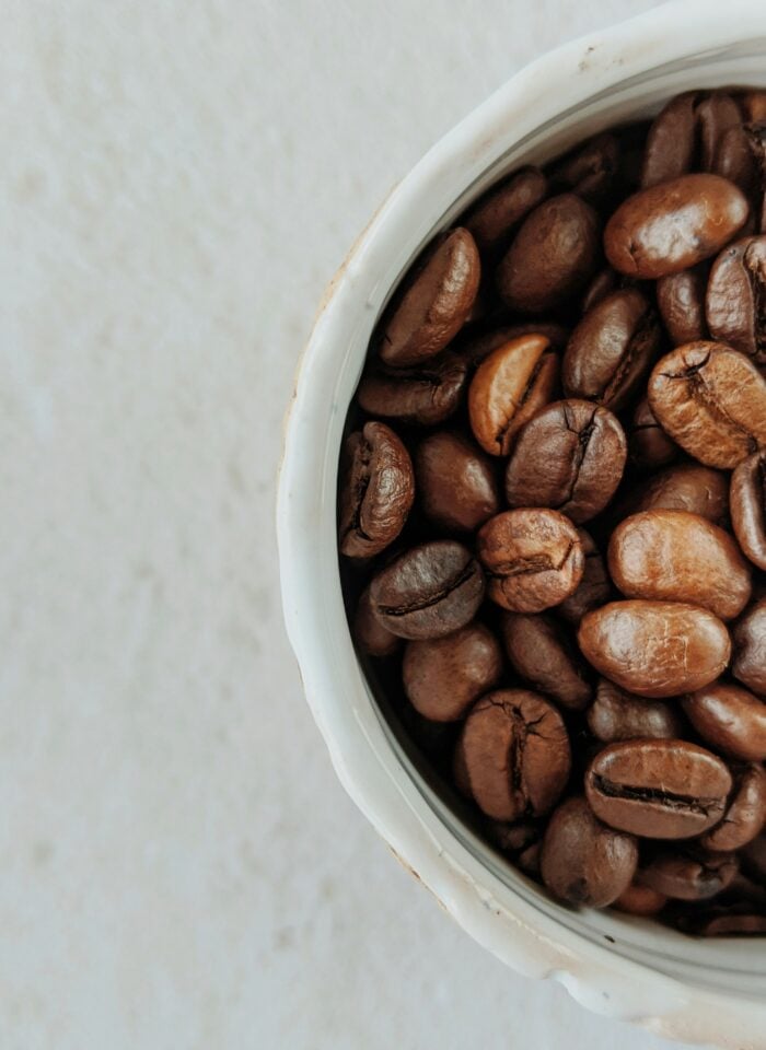 Close-up of roasted coffee beans in a ceramic cup