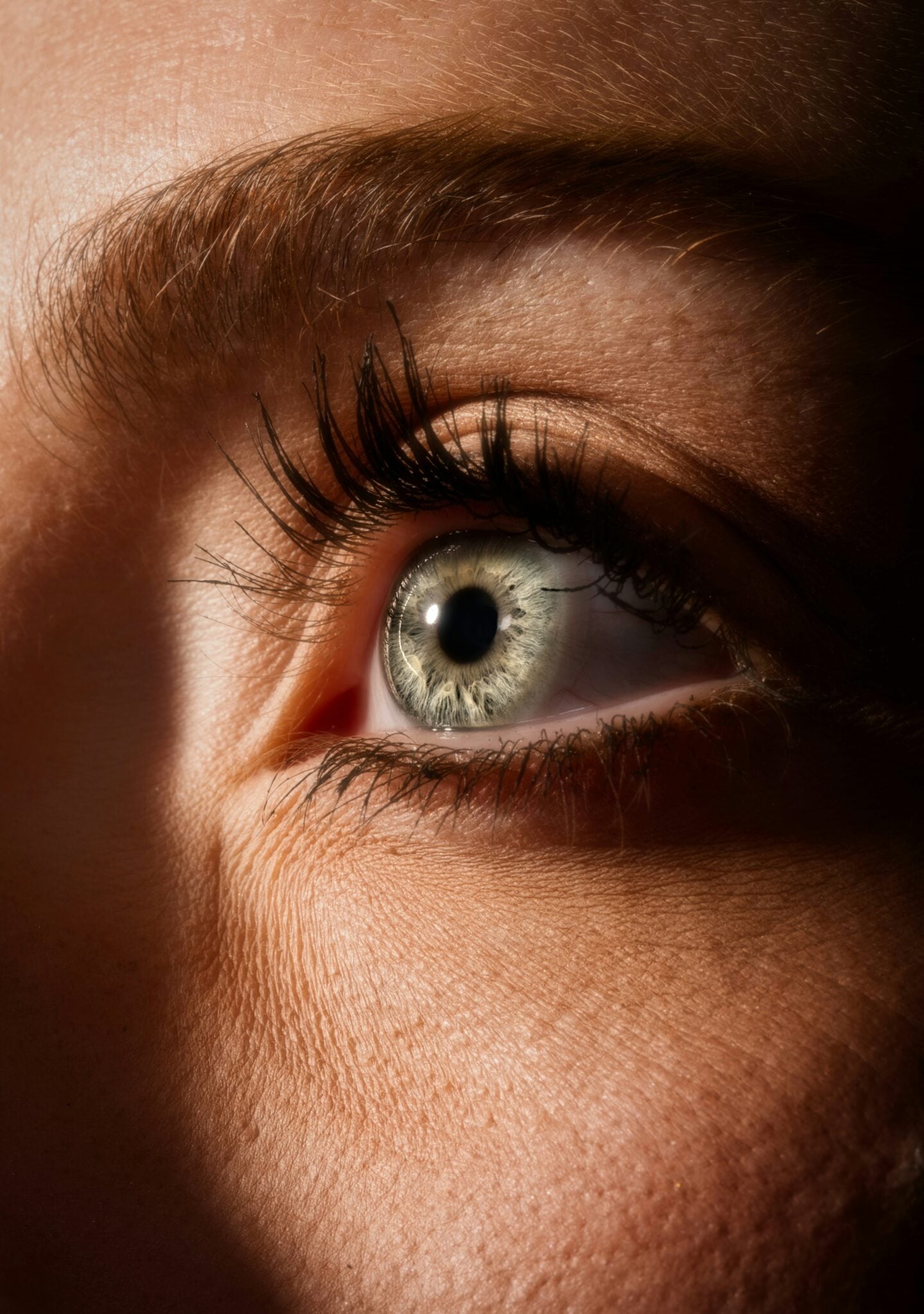 Close-up of a bright blue eye with long lashes in natural light, symbolizing healthy vision care.