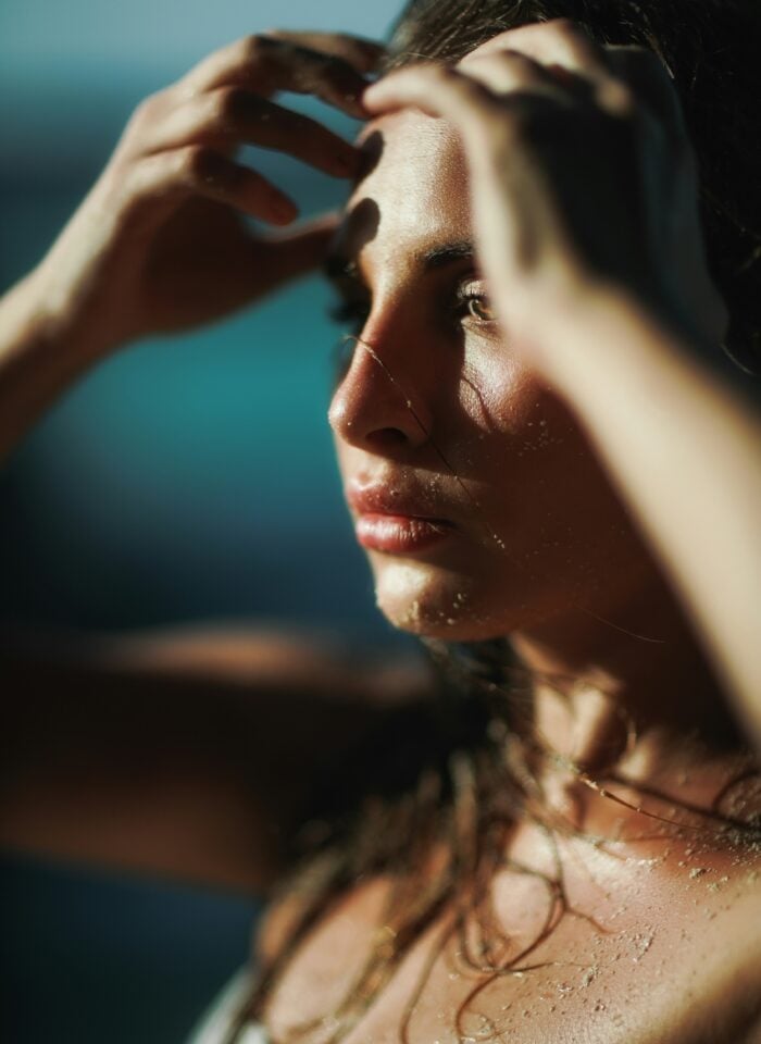 Close-up of a woman with wet hair and dewy skin, showing fresh post-beach glow and natural skin hydration.