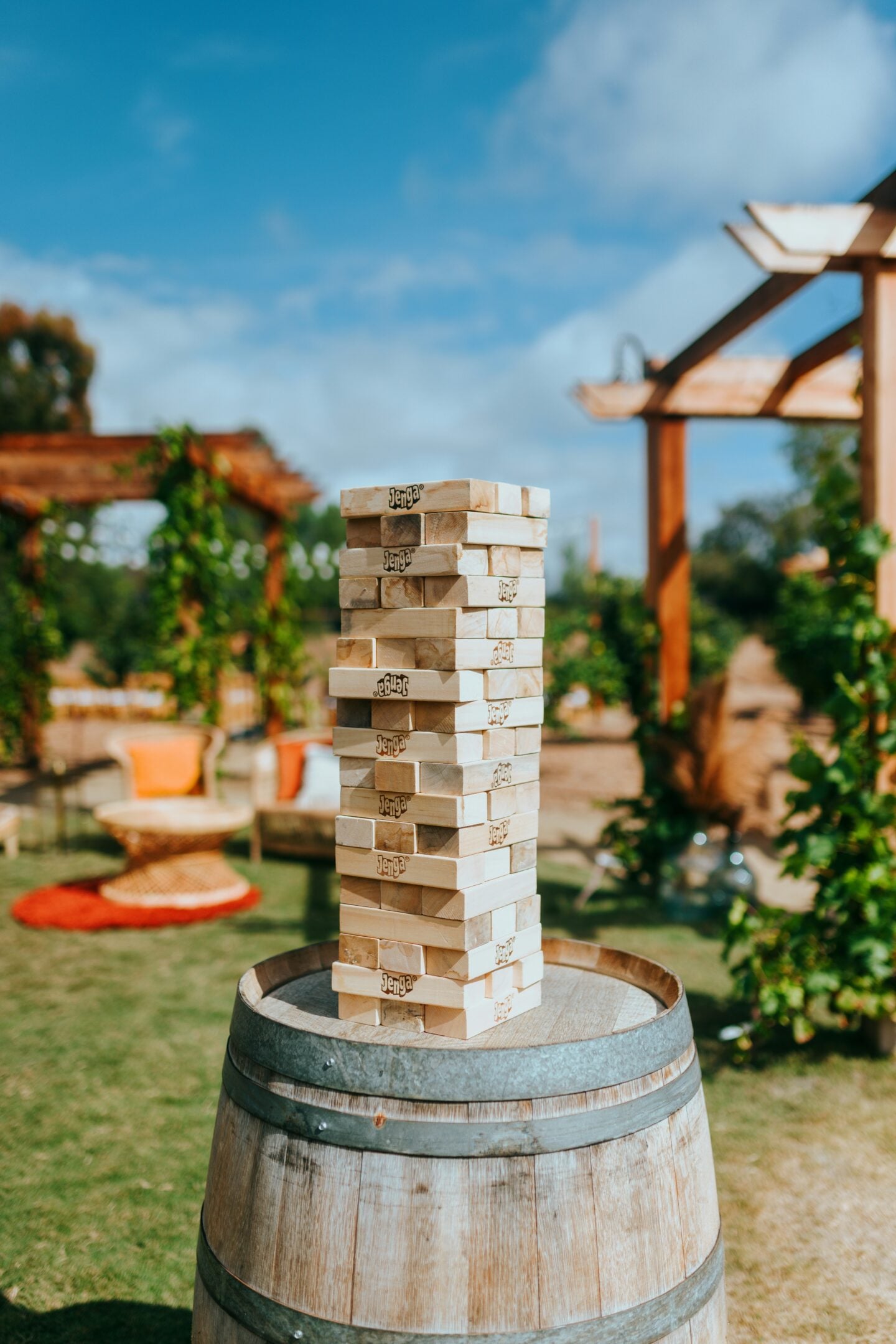 Outdoor giant Jenga game stacked on a wooden barrel.