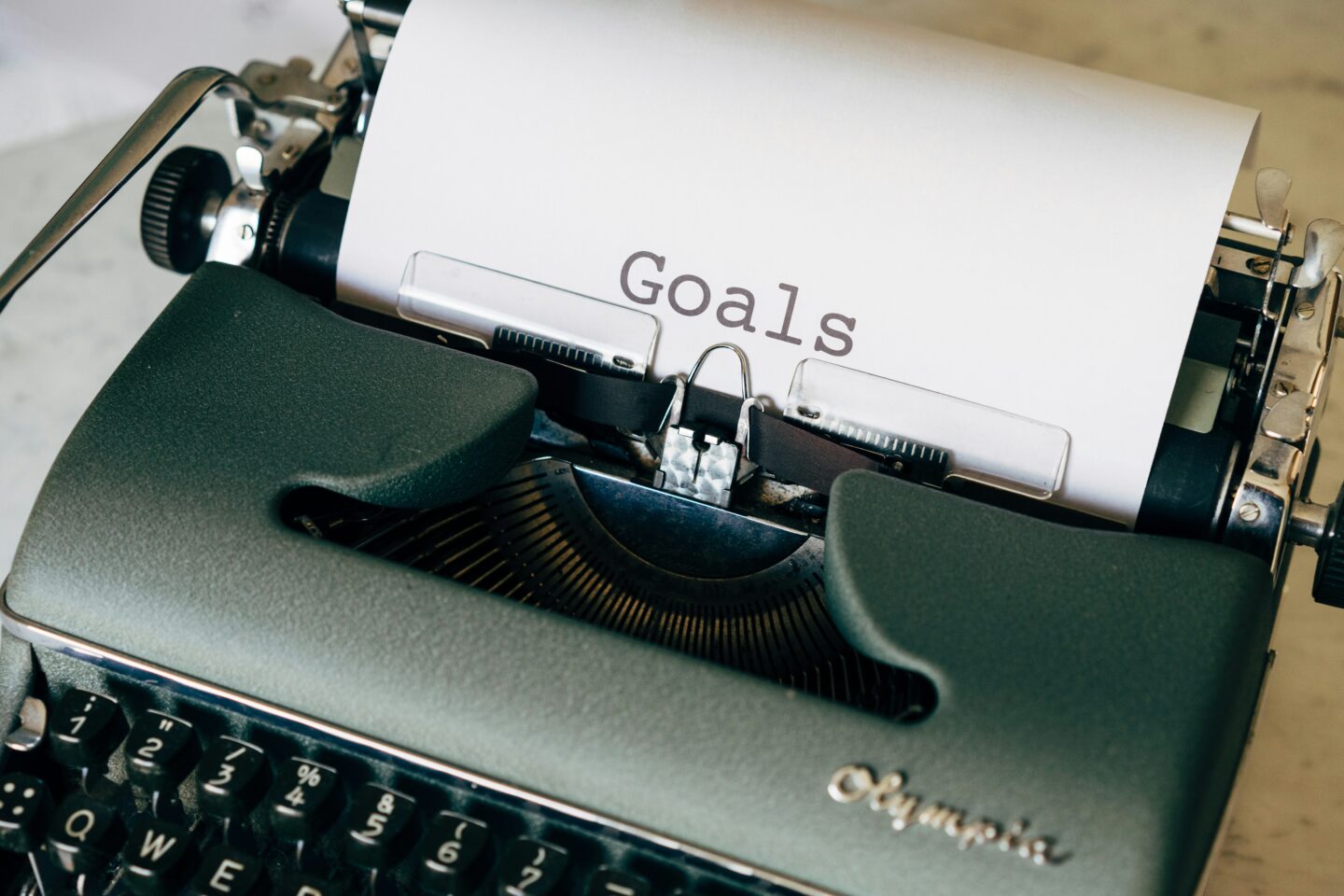 A vintage typewriter with a sheet of paper that has the word “Goals” typed on it.