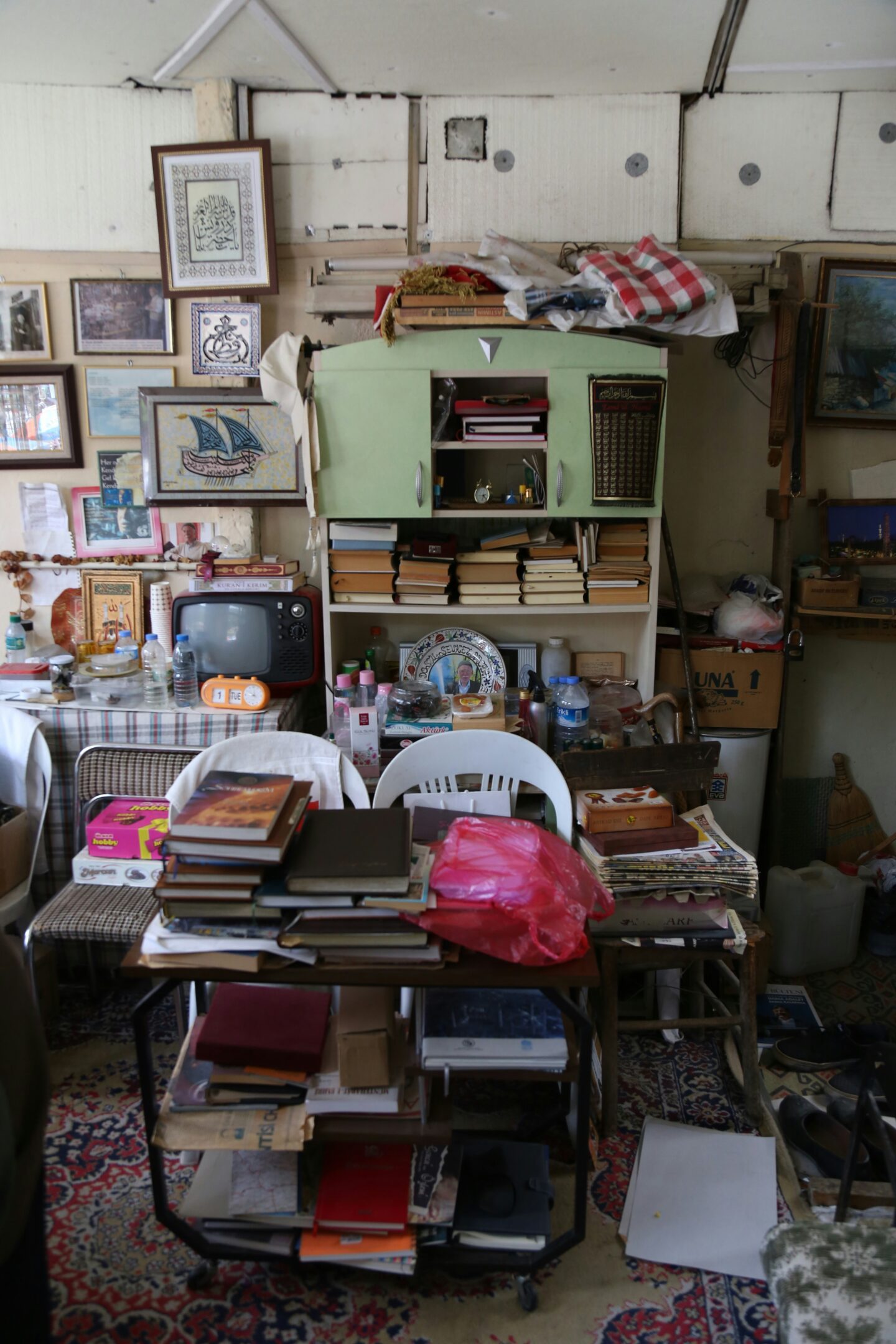 Cluttered room filled with piles of books, papers, and household items, illustrating the need for decluttering, junk removal, and home organization.