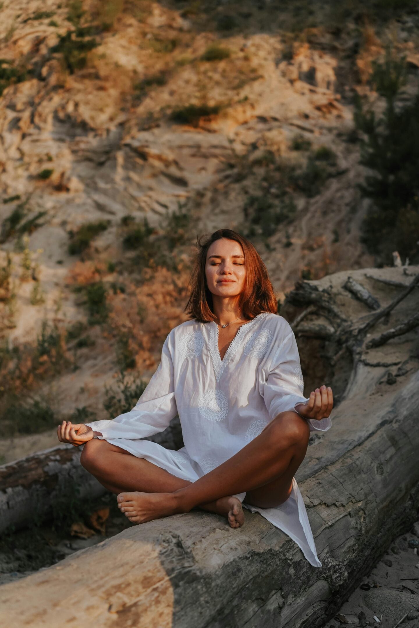 Woman meditating outdoors on a sunny day, benefiting from natural light for eye wellness.