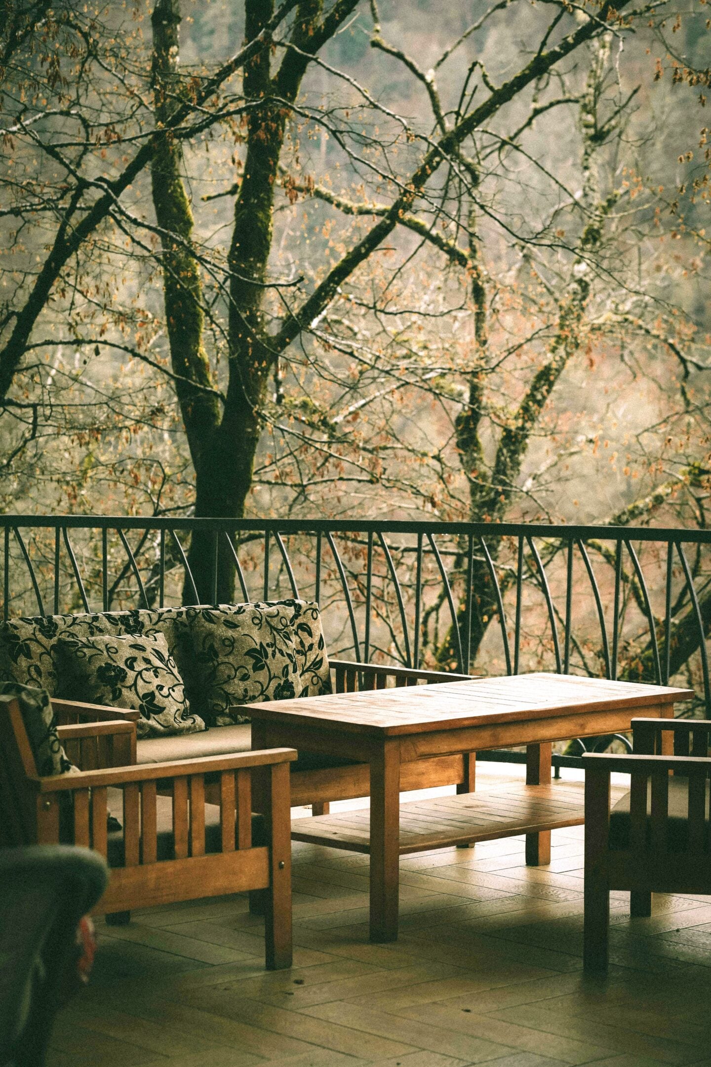 Cozy outdoor loggia with wooden furniture on an upper-level balcony, perfect for upside-down home designs with living areas upstairs.