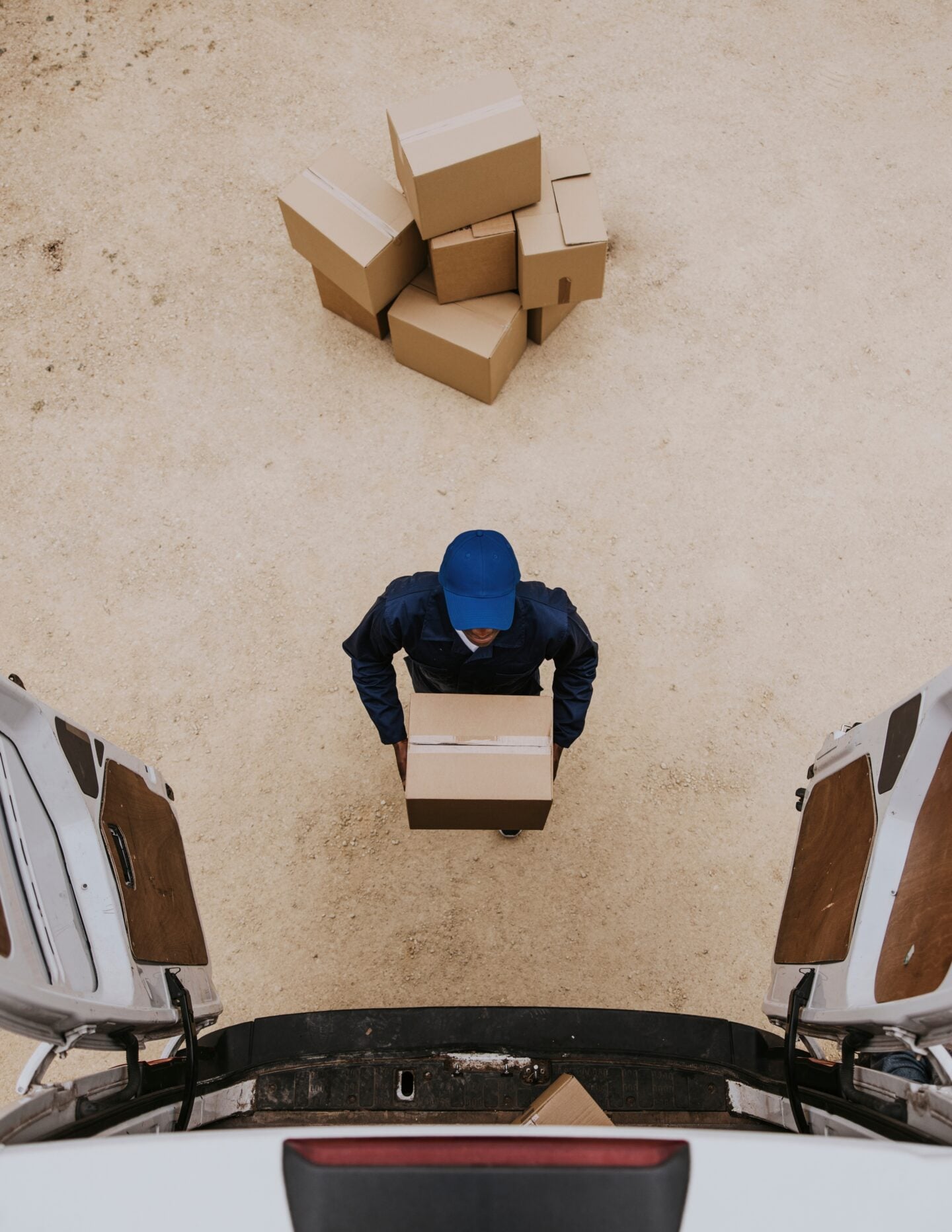 Removal service worker unloading box from the van.