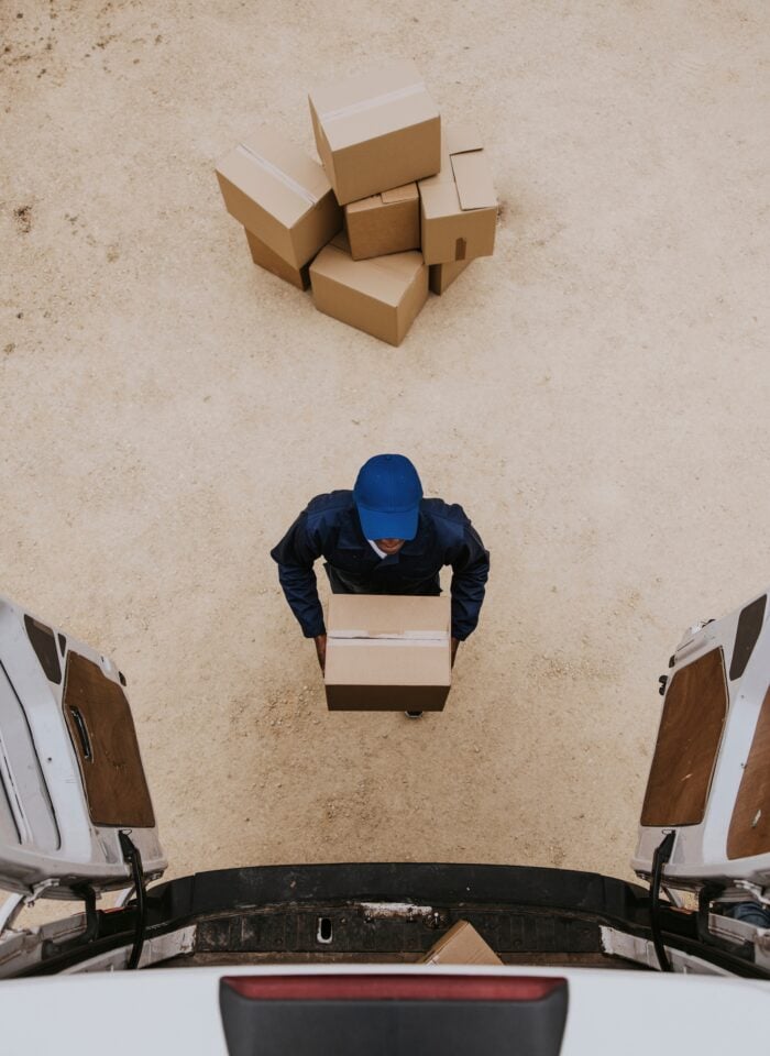 Removal service worker unloading box from the van.