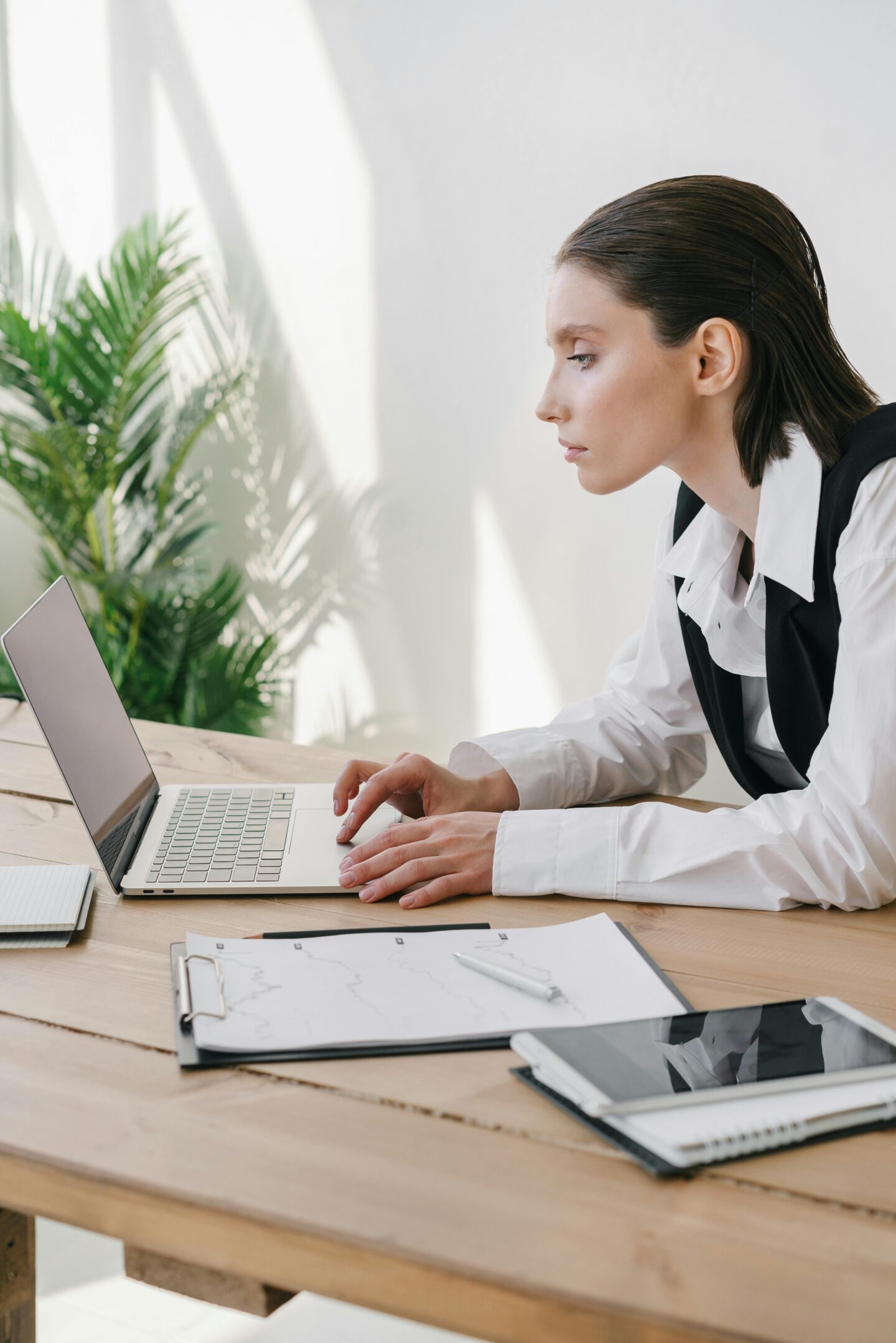 Professional woman working on a laptop in a bright modern office — focused accountant or entrepreneur planning business growth.