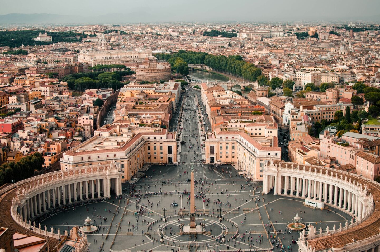 Aerial view of St. Peter’s Square and surrounding buildings in Vatican City, showing the layout and crowds below.