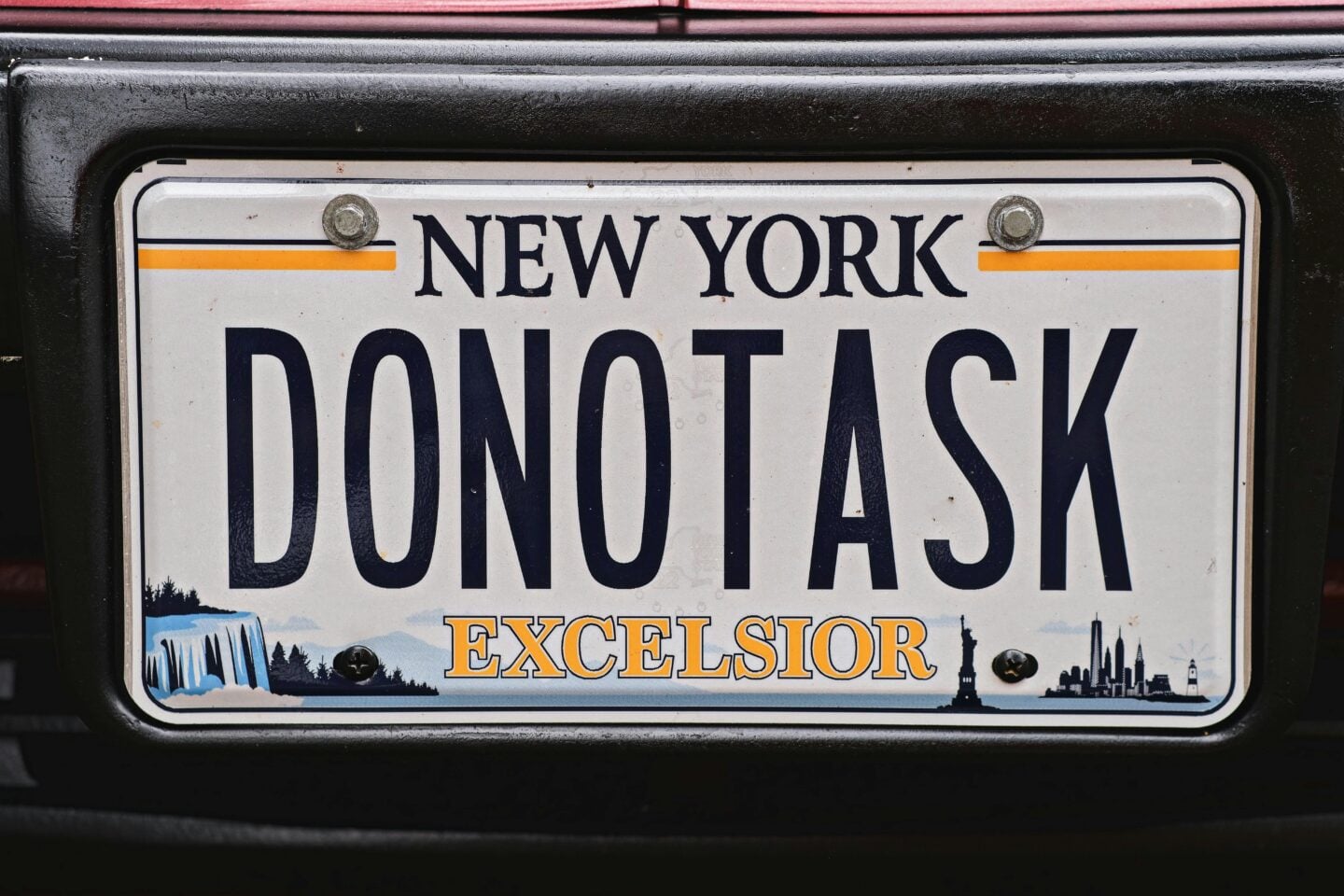 Close-up of a New York personalized license plate with the custom text “DONOTASK”.
