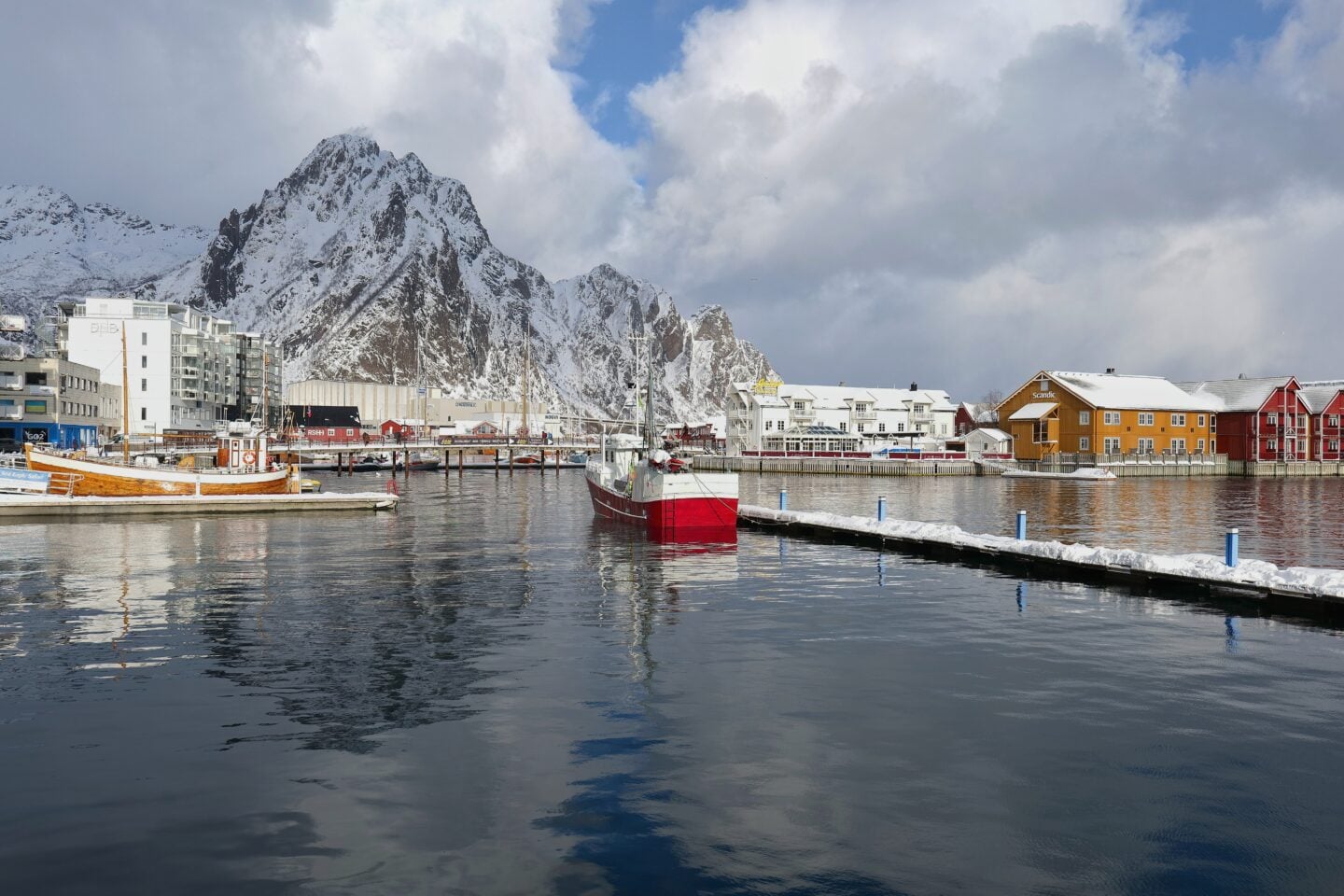 Harbor view of Svolvær with boats, waterfront buildings, and dramatic mountains in Lofoten, Norway