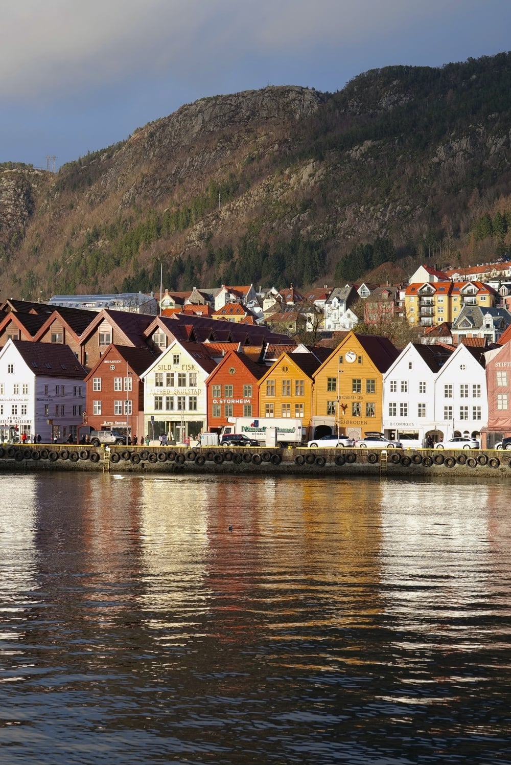Bryggen waterfront with colorful wooden houses reflected in the harbor, Bergen, Norway