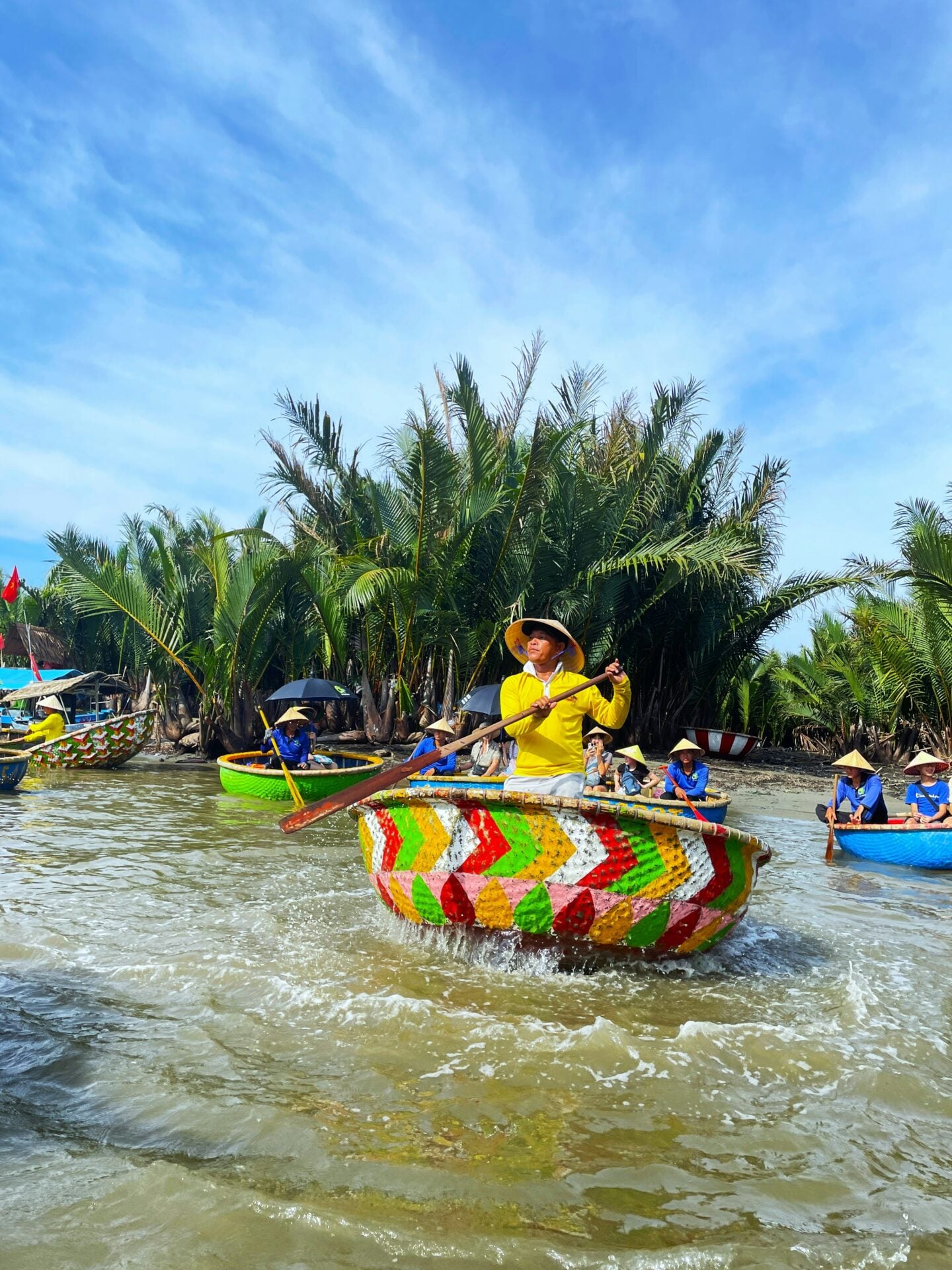 Traditional colorful basket boats rowed through the coconut palms of Cam Thanh near Hoi An, Vietnam.