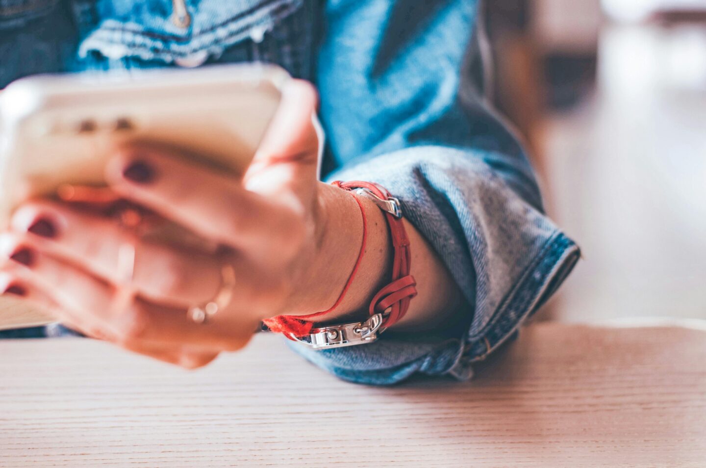 Hands holding a mobile phone on a table