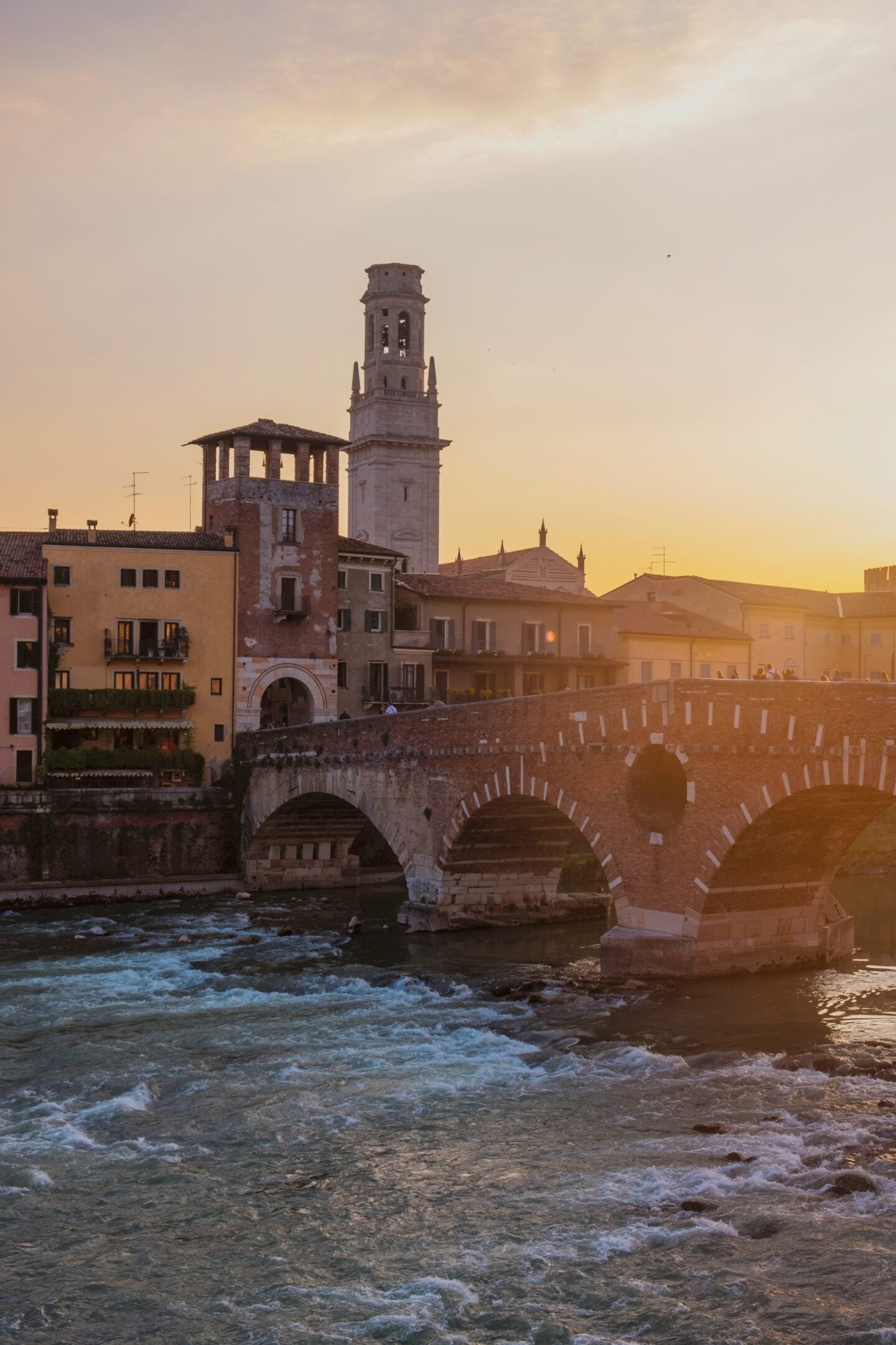 Ponte Pietra stone bridge crossing the Adige River at sunset in Verona, Italy