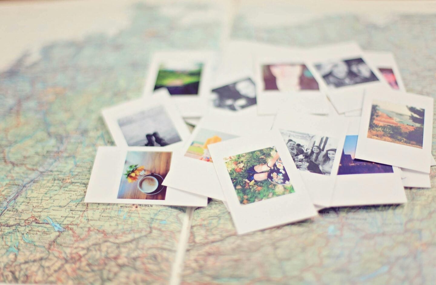 Scattered instant photos placed on top of a map, showing travel moments, landscapes, and everyday details from different trips.