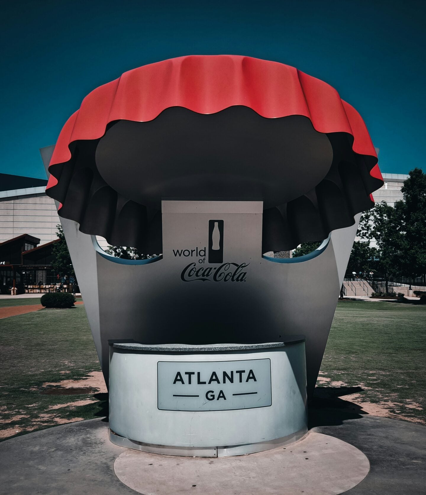 The World of Coca-Cola entrance display in Atlanta, featuring a large red-and-black bottle-cap sculpture.