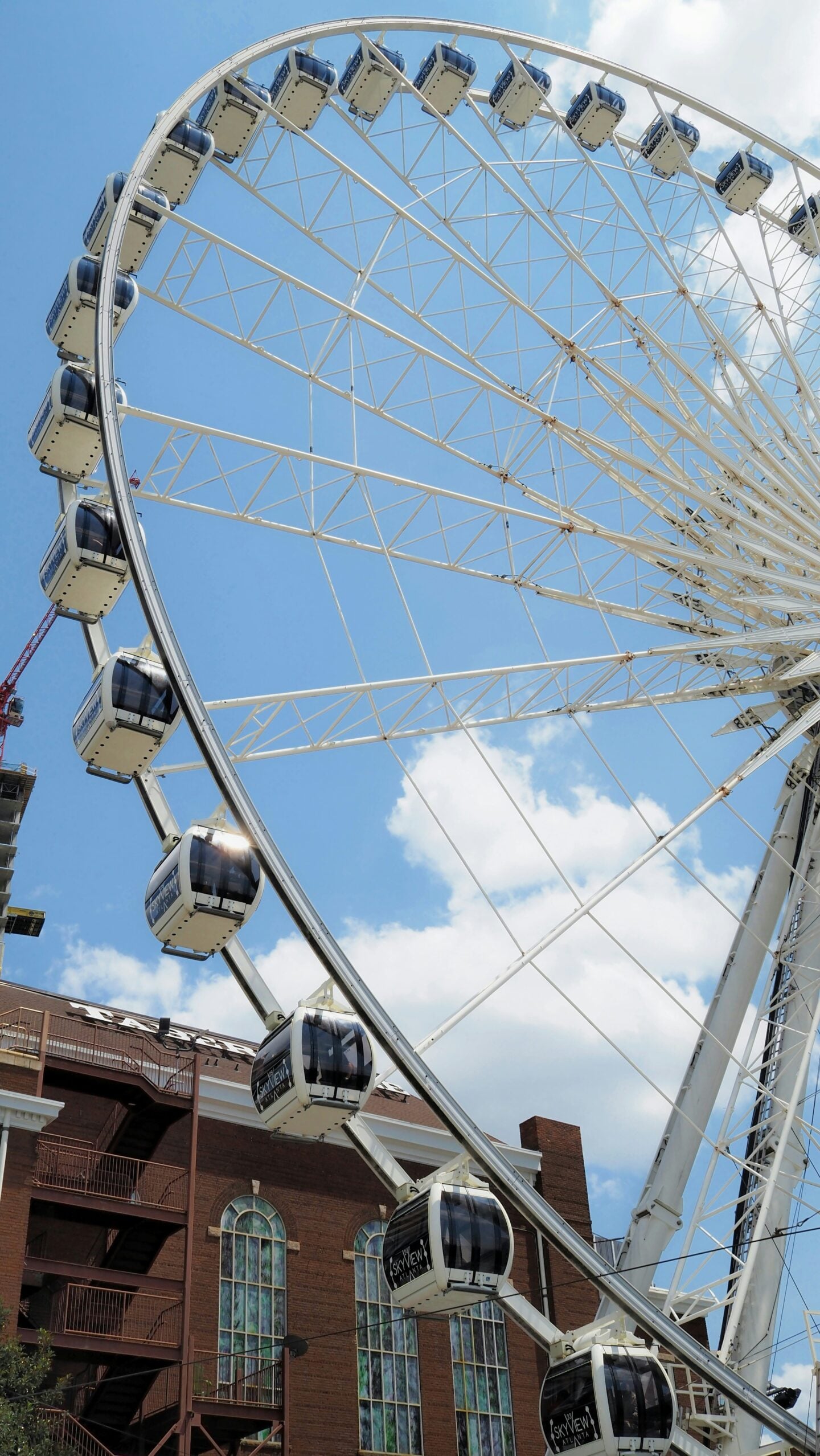 A close-up view of the SkyView Atlanta Ferris wheel cabins against a bright blue sky.
