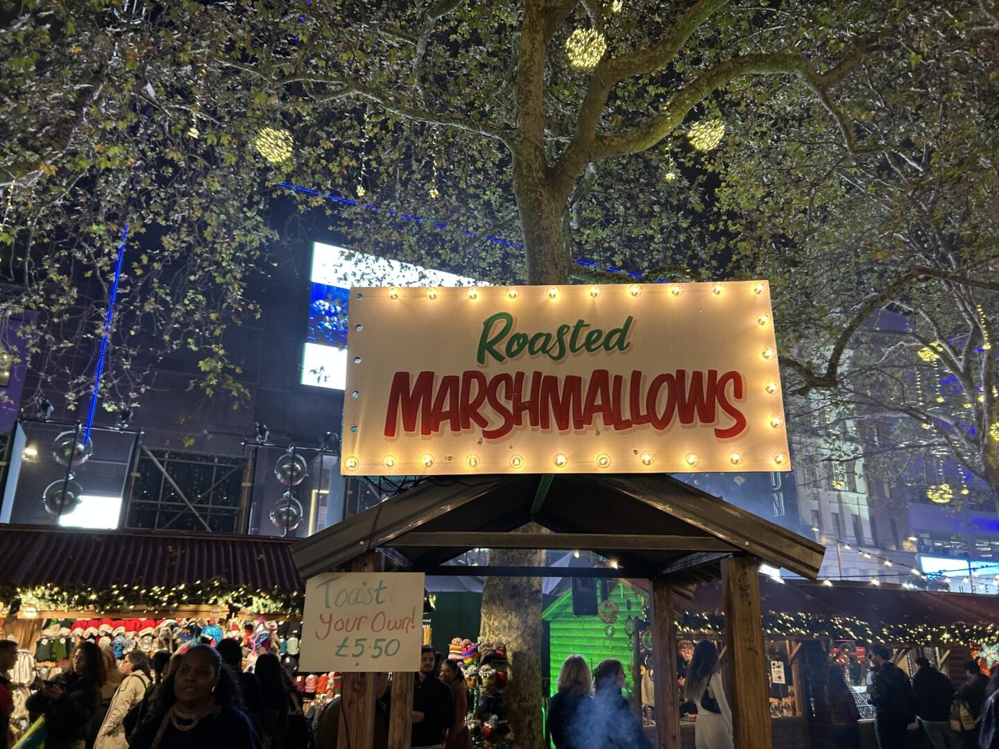 Roasted marshmallows stall at a London Christmas market at night, one of the most festive things to do in London in winter.