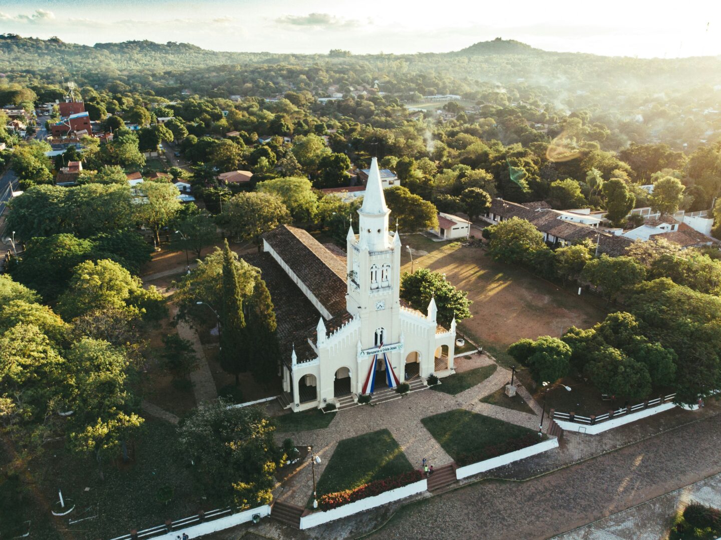 Aerial view of a historic white church surrounded by greenery in Areguá near Asunción, Paraguay