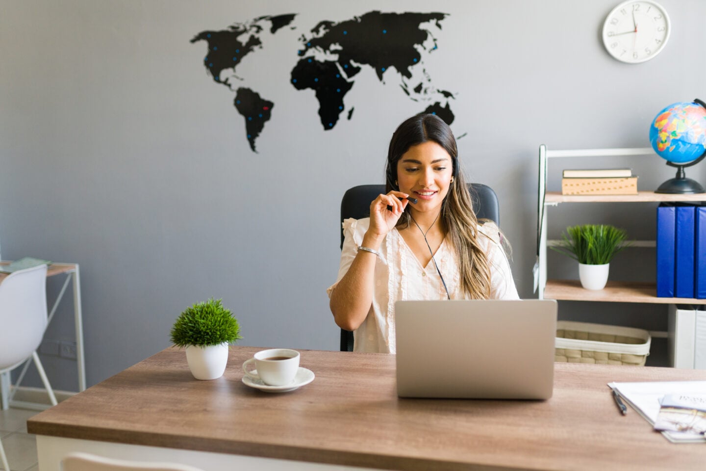 Young woman working at a travel agency and talking with a client