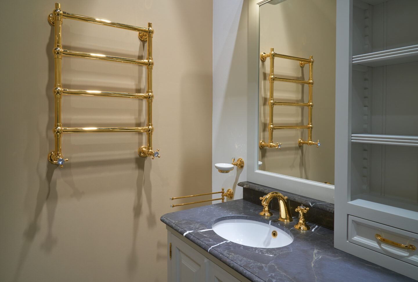 Luxury interior bathroom with gold towel warmer, brass fixtures, marble countertop, and classic vanity design