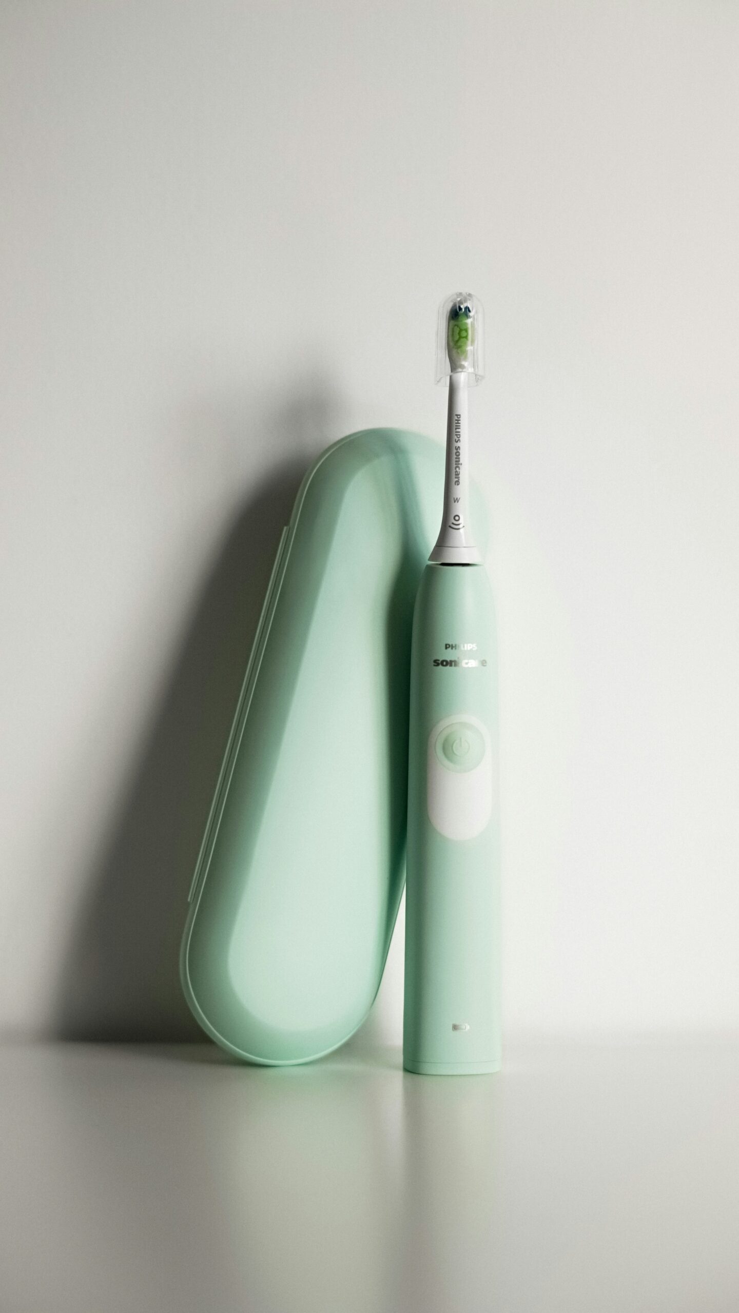 Electric toothbrush with travel case on a white surface, representing daily oral care and advanced dental hygiene tools.
