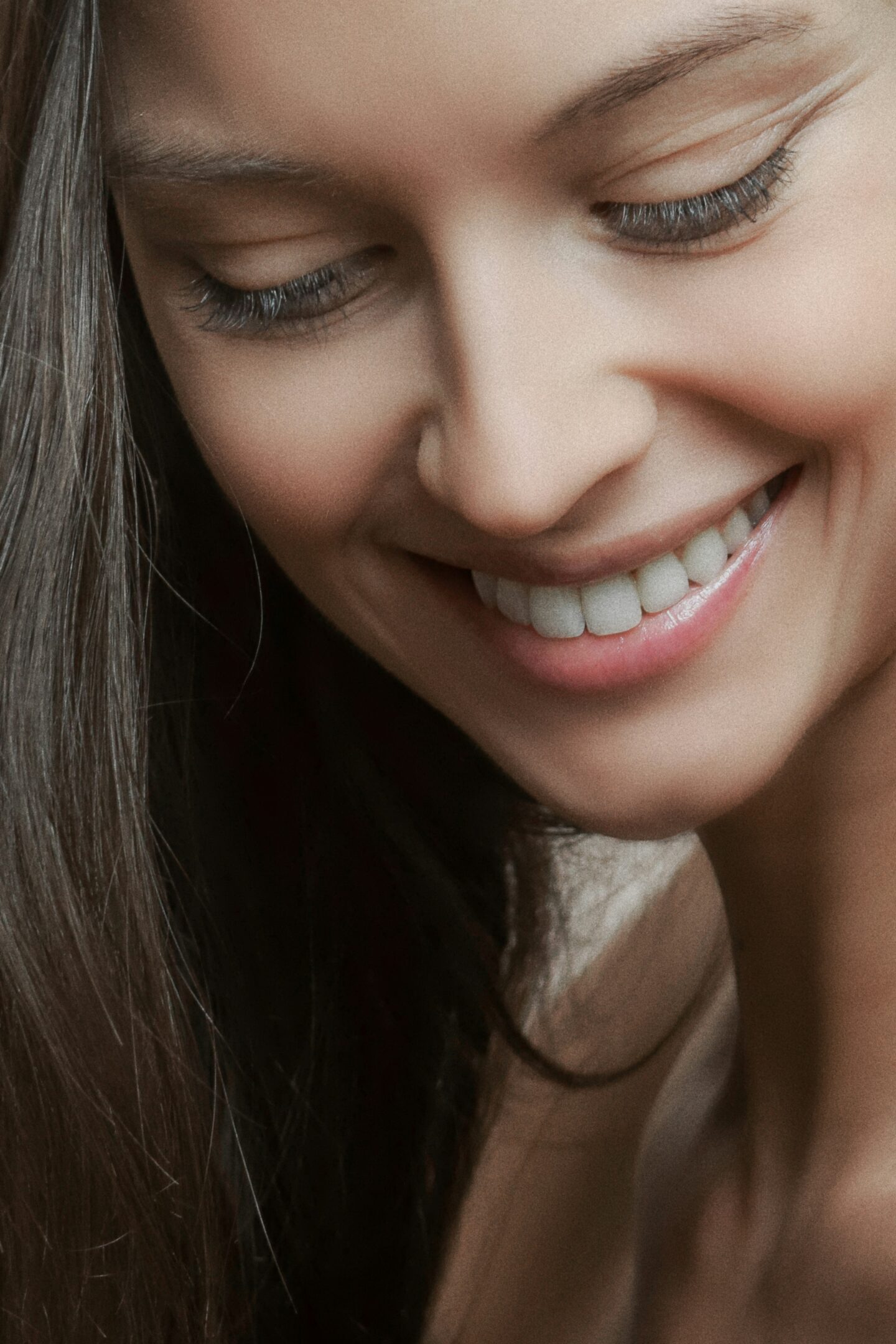 Close-up of a smiling woman with healthy white teeth, highlighting natural smile and good oral hygiene.