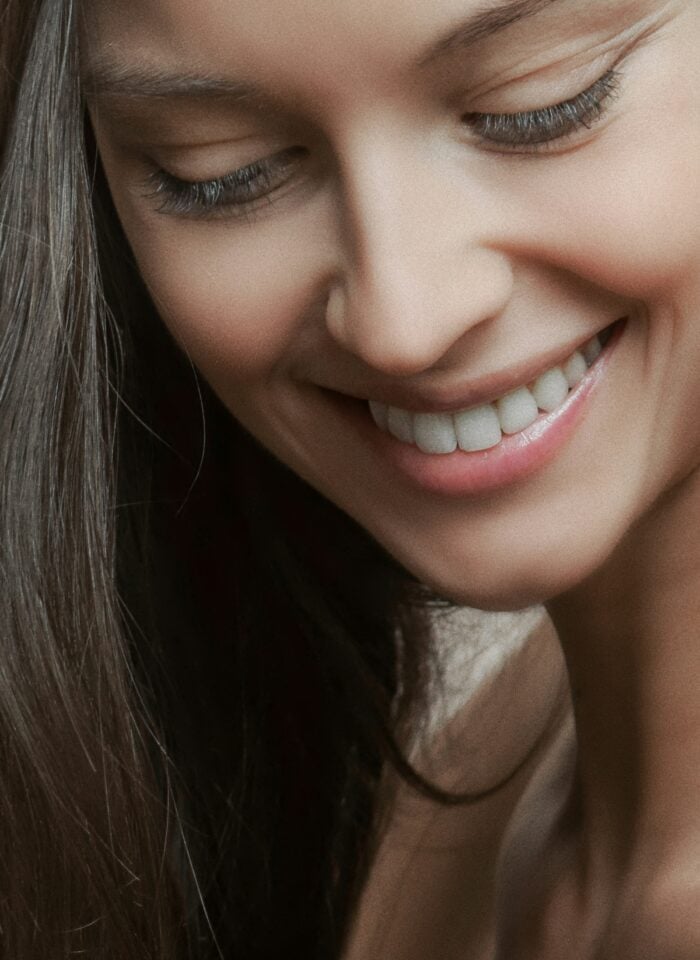 Close-up of a smiling woman with healthy white teeth, highlighting natural smile and good oral hygiene.