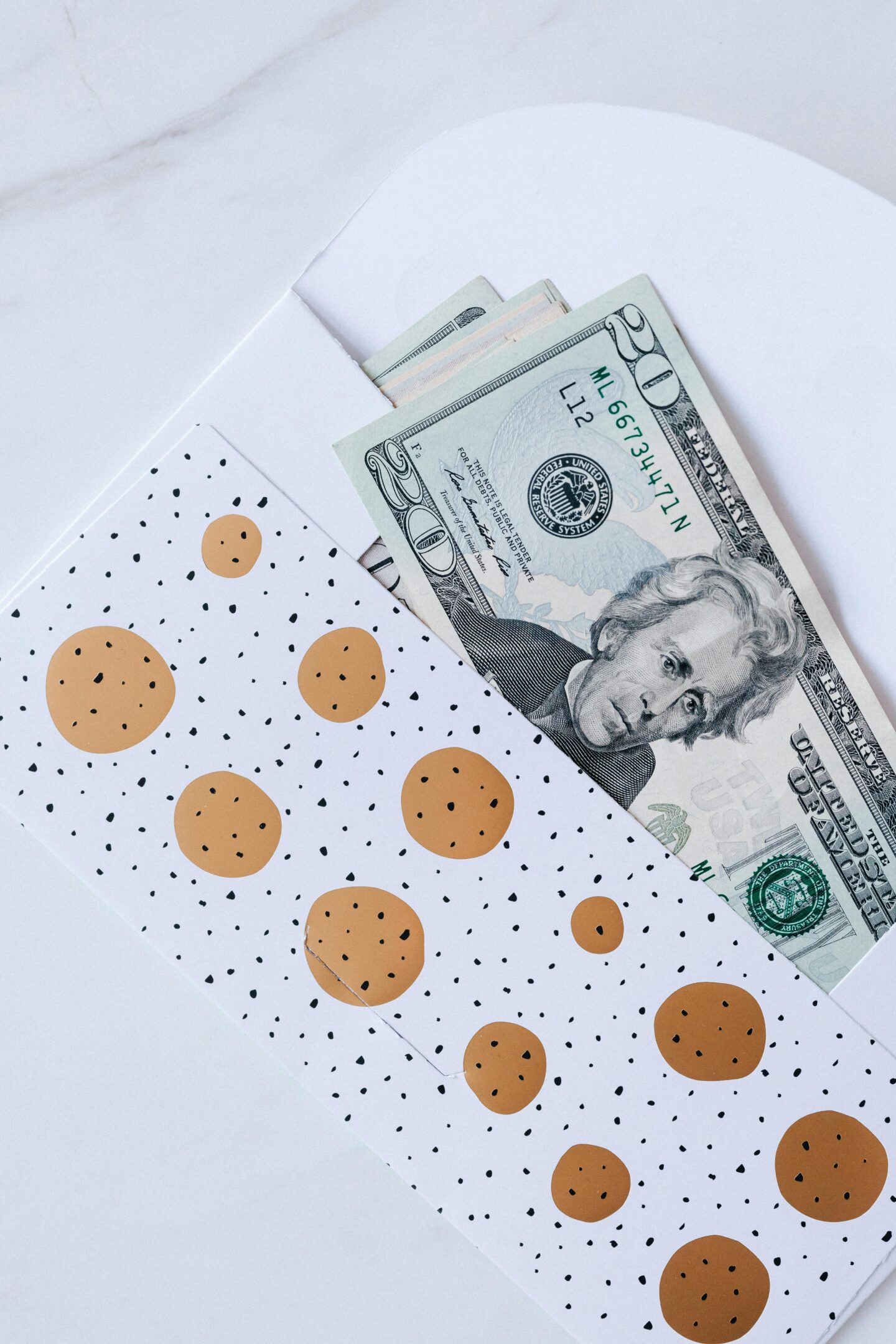 Cash gift in decorative envelope with US dollar bills, practical monetary wedding present for newlyweds.