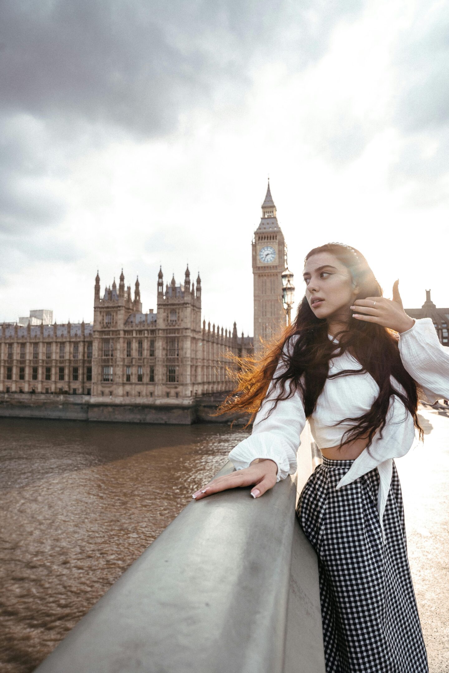 Woman standing on Westminster Bridge with Big Ben and Houses of Parliament in London at sunset