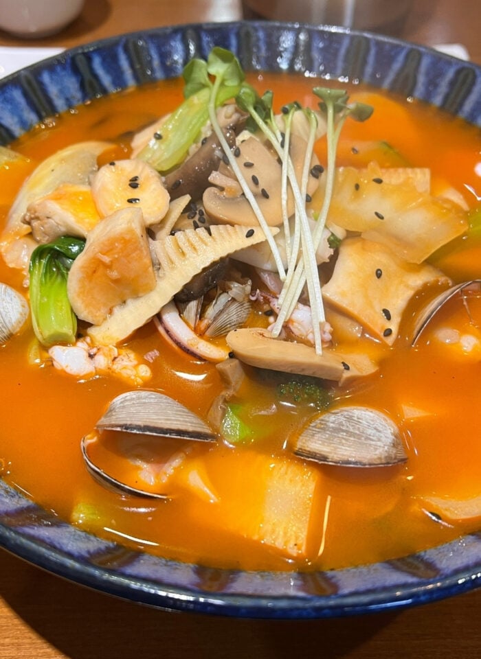A bowl of South Korean soup with seafood.