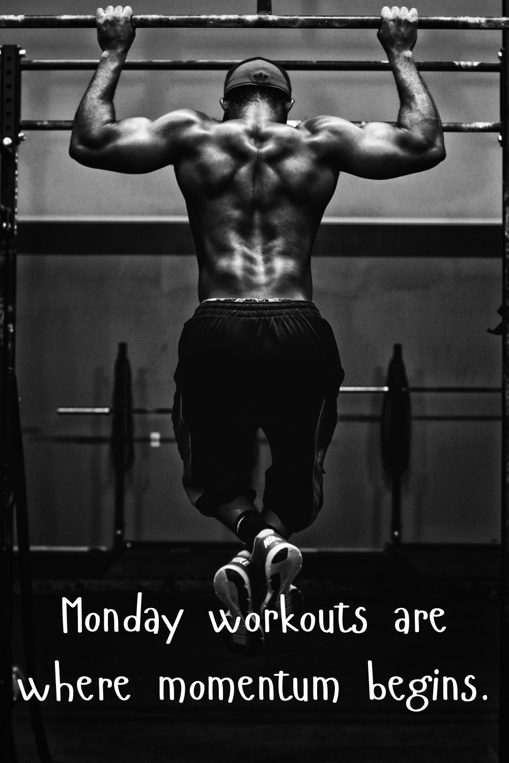 Black and white photo of a man doing pull-ups in the gym with the quote “Monday workouts are where momentum begins.”