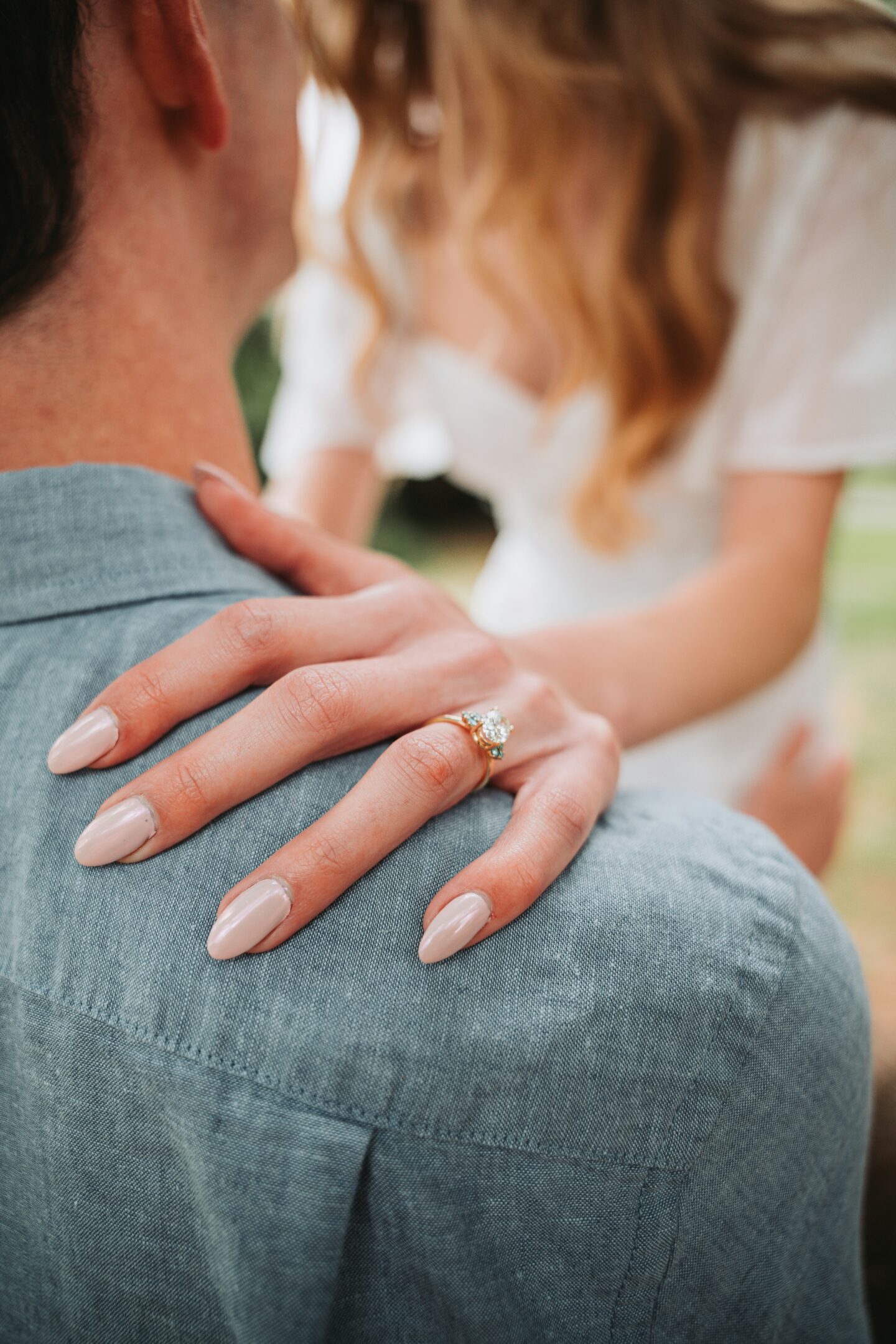 Close-up of a solitaire diamond engagement ring being placed on a woman’s finger, symbolizing a romantic proposal and timeless jewelry style.