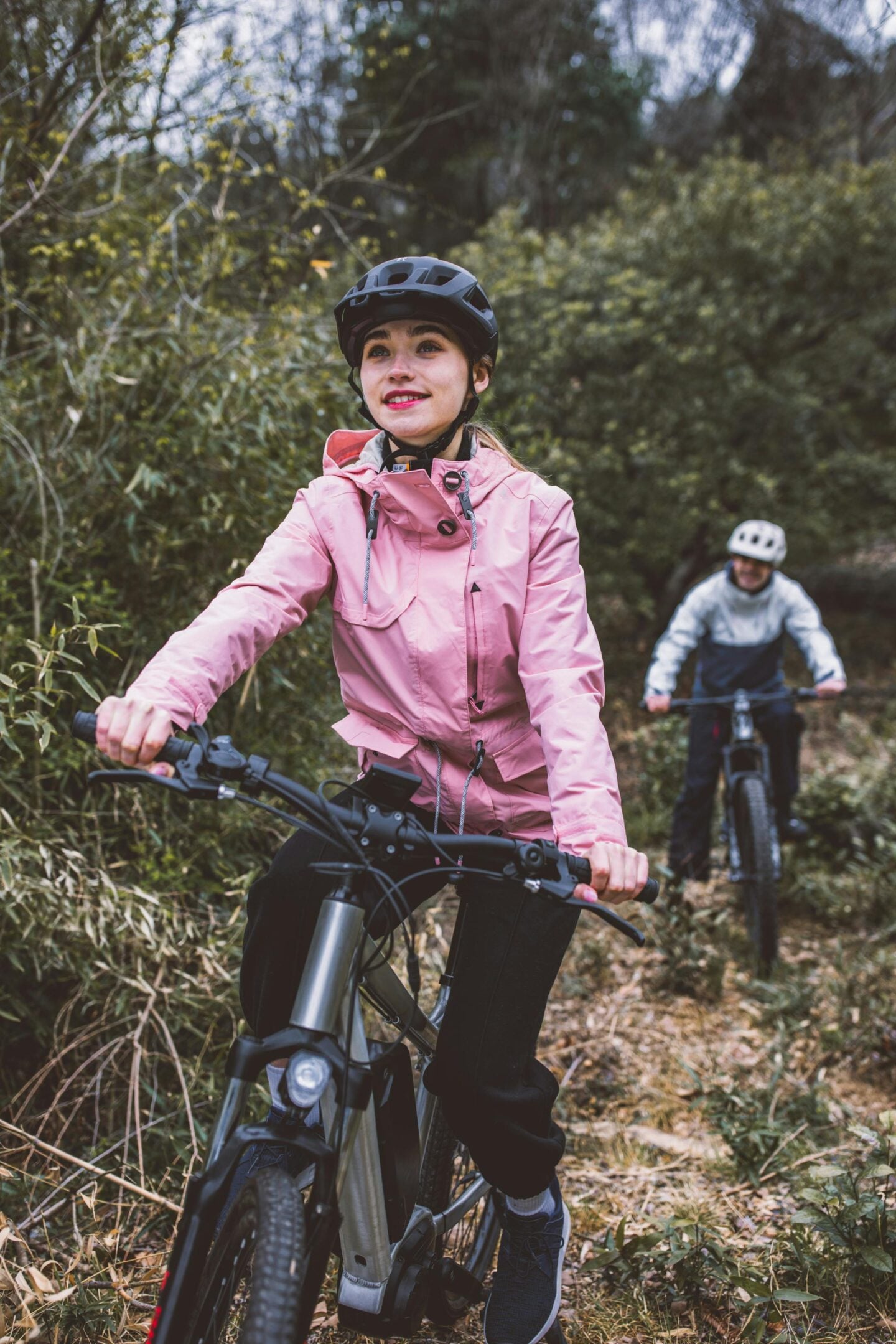 Couple riding on bikes in a forest.