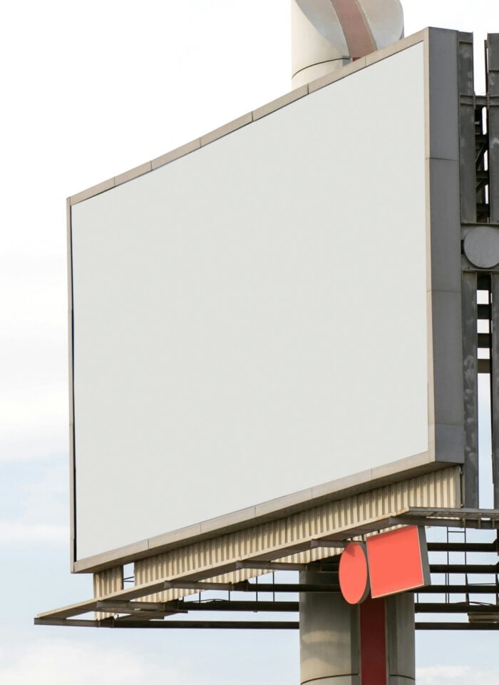Blank roadside billboard advertising display with metal frame structure against a cloudy sky