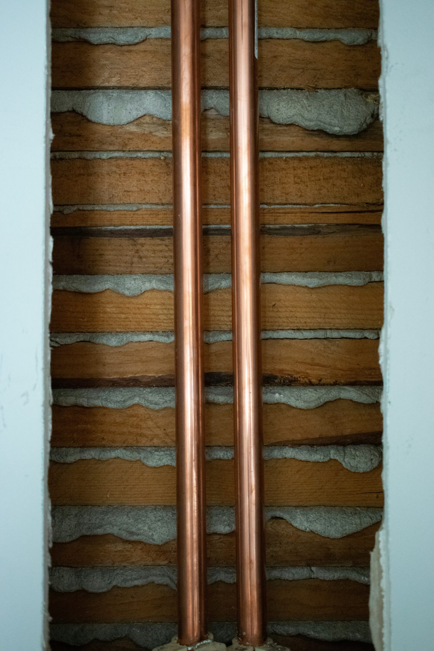 New copper plumbing pipes installed vertically inside an exposed interior wall during home renovation or plumbing upgrade.