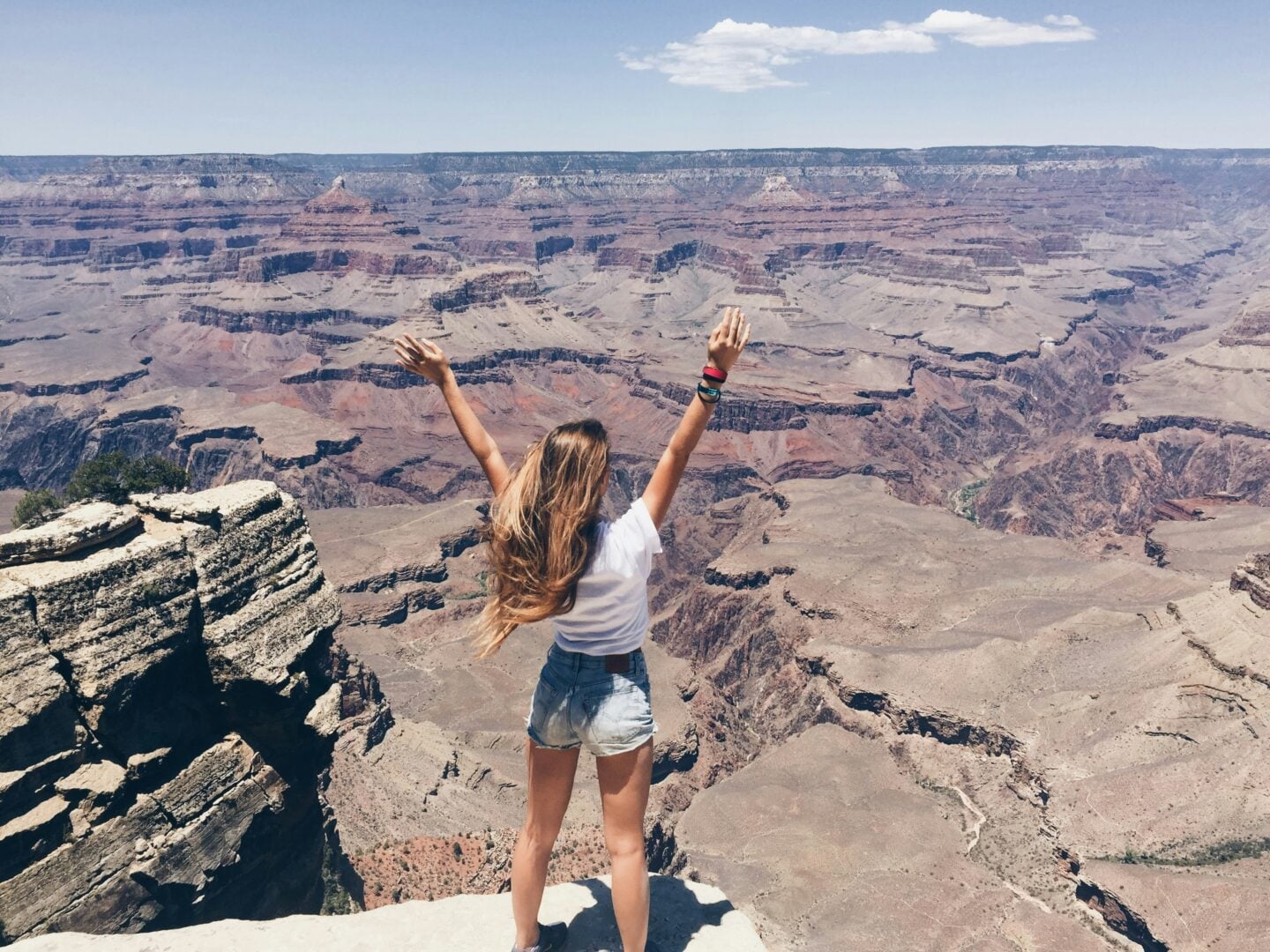 Traveller standing at a scenic canyon viewpoint, embracing the beauty of exploring the world and creating meaningful travel experiences.
