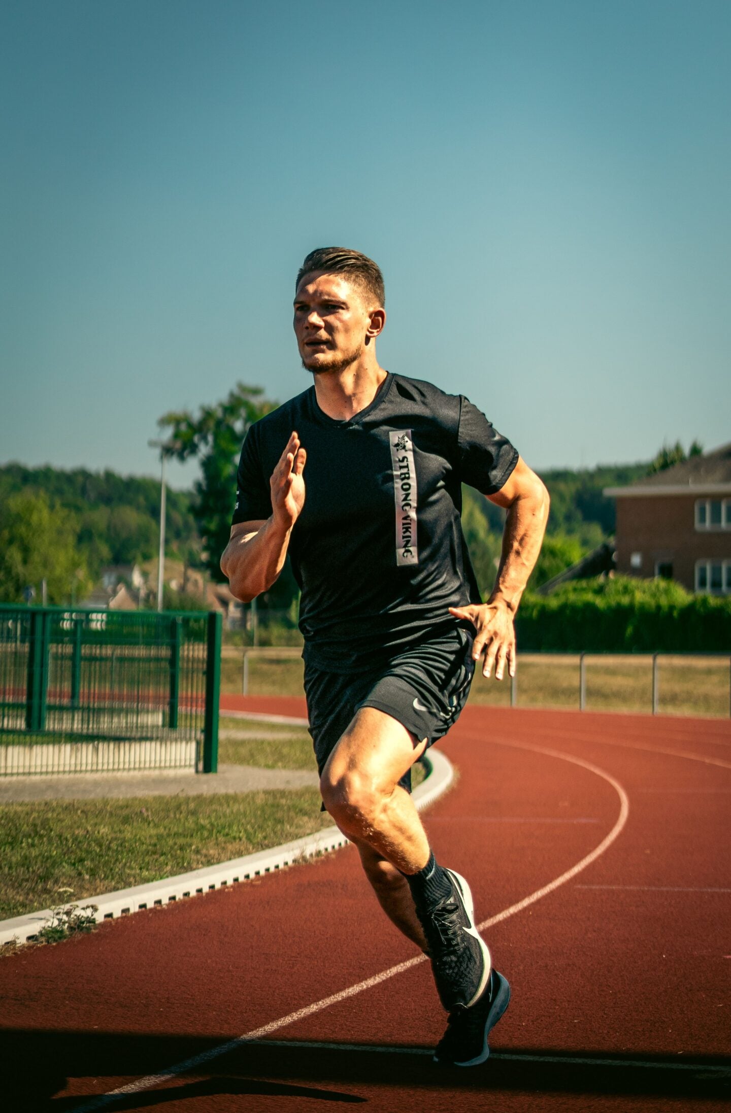 Athlete sprinting on a running track during sports performance training.