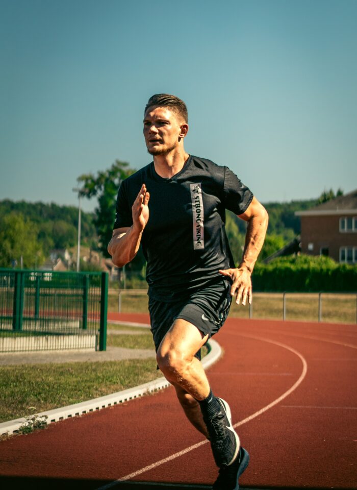 Athlete sprinting on a running track during sports performance training.