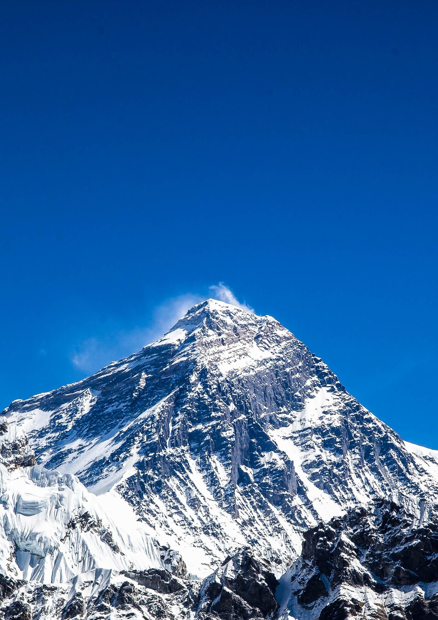 Breathtaking view of Mount Everest with a clear blue sky backdrop, showcasing its snow-capped peak.