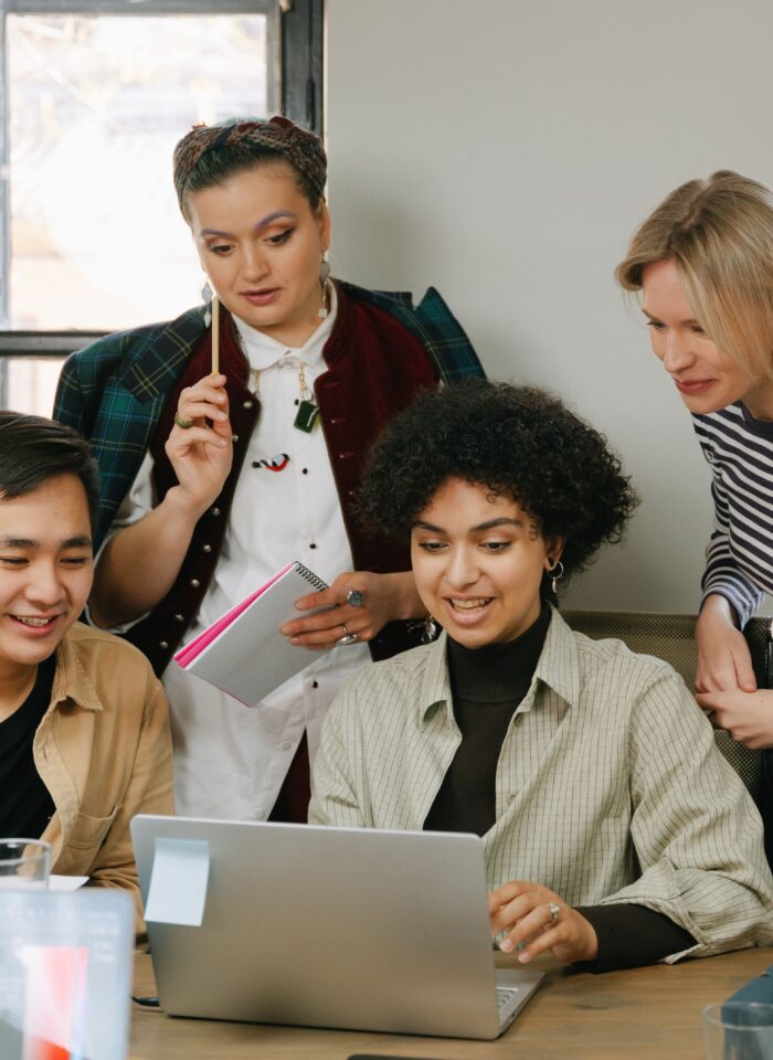 Business professionals collaborating around a laptop while planning a data-driven marketing strategy.