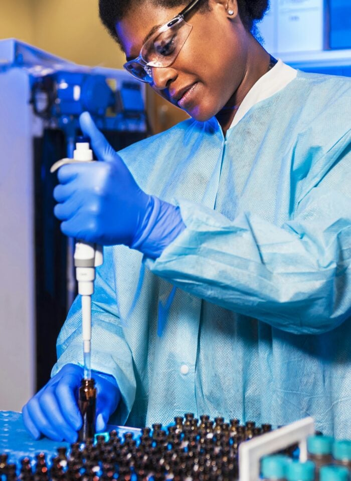 Scientist using a pipette in a pharmaceutical laboratory while supporting sustainable manufacturing and green chemistry research