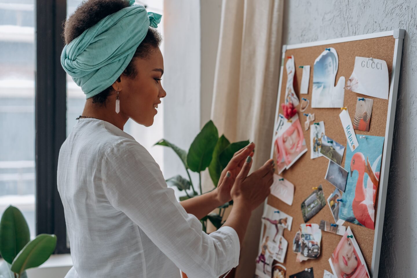 Woman creating a vision board with magazine cutouts as a relaxing DIY project.