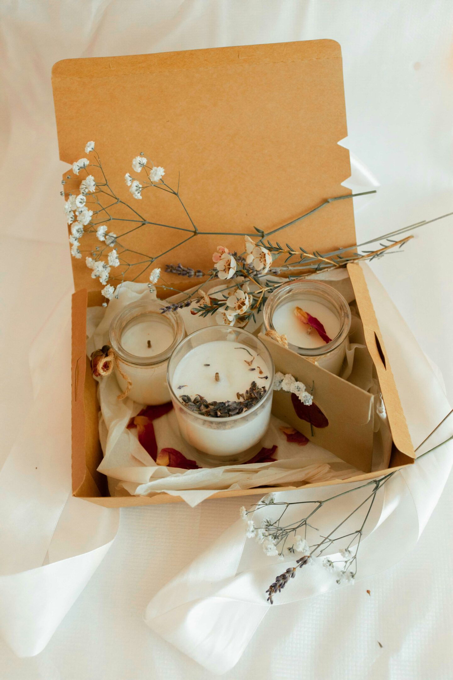 Handmade gift box filled with scented candles, dried flowers, and decorative packaging.
