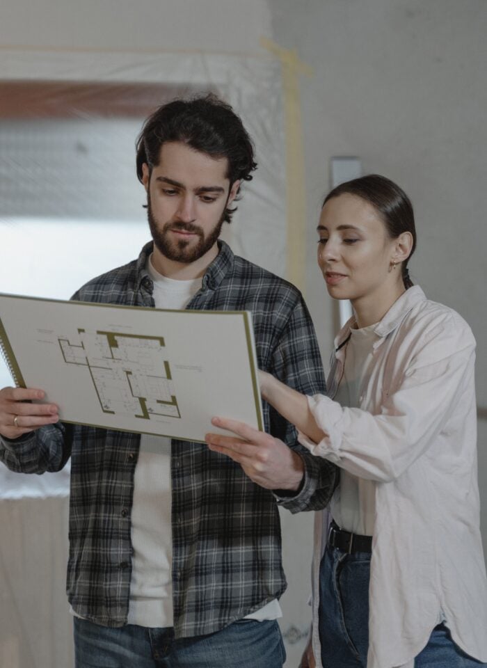 Homeowners reviewing renovation plans together while planning a major home improvement project and budgeting for upgrades.